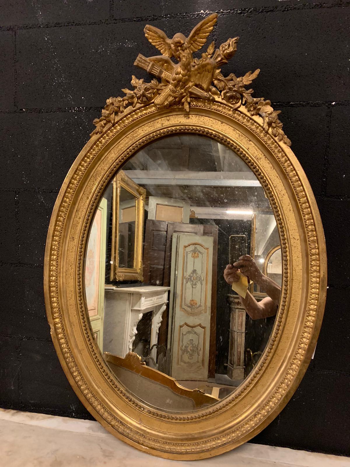 Antique oval mirror in gilded wood, hand-carved with ancient symbols such as the little bird (lucky charm), arrows and flames, hand-built in the 19th century in Italy.
Good size and beautiful shape, richly sculpted but also simply elegant, ideal as
