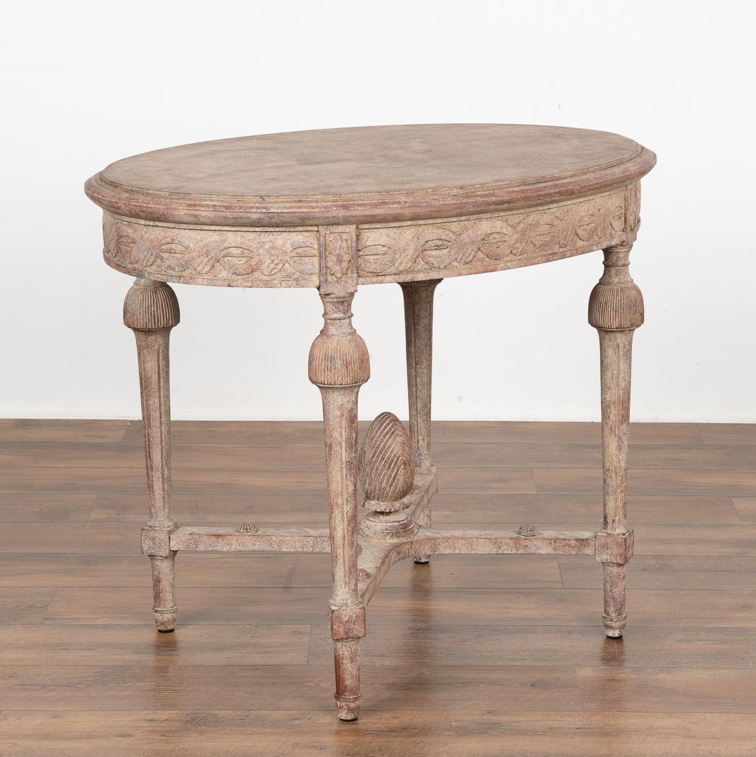 Lovely oval side table with turned legs, decorative carved skirt and egg shaped finial on X stretcher base.
Restored, later professionally painted in muted shades of plum, white and blush, all lightly distressed to fit the age and grace of this