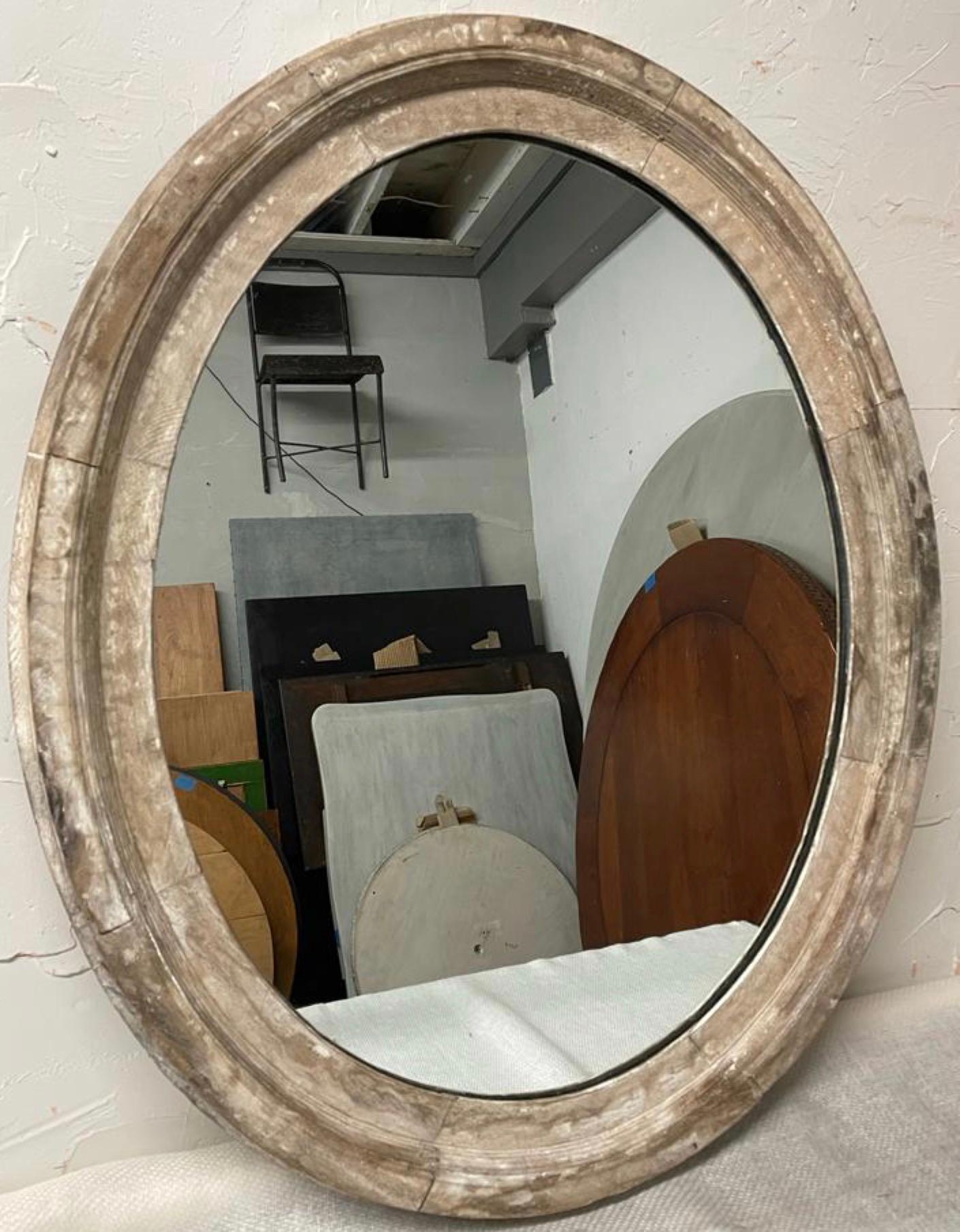 Wonderfully rustic French country painted wood oval mirror with much of its original finish lost but the remaining antique white distressed paint with wonderful aged patina adds a rustic yet chic antique touch to any living room, hallway, bedroom or