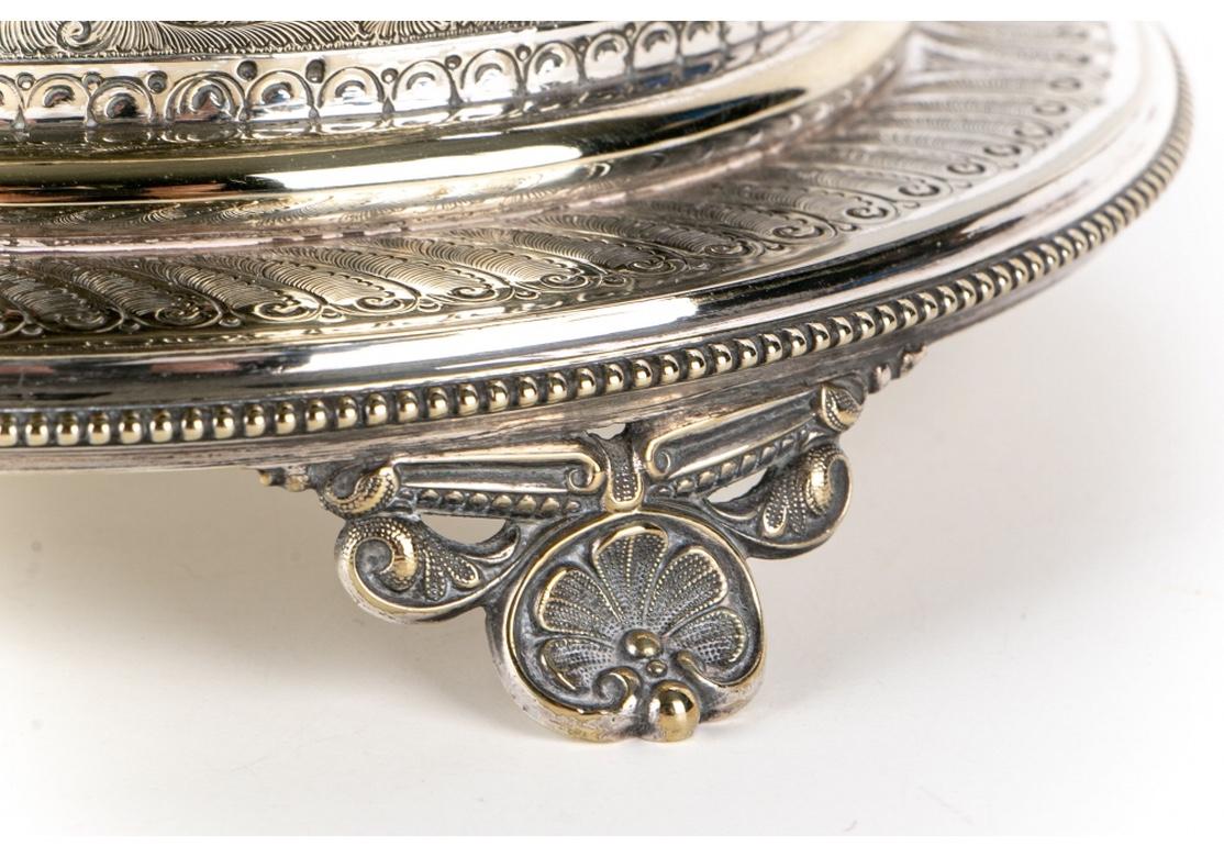 A fine silver plate biscuit box on stand with overall chased decoration with scrolled a leafy bands and medallions. Raised on shell form feet. With good weight and in very good condition with maker marks on the base. Slight tarnish easily polished