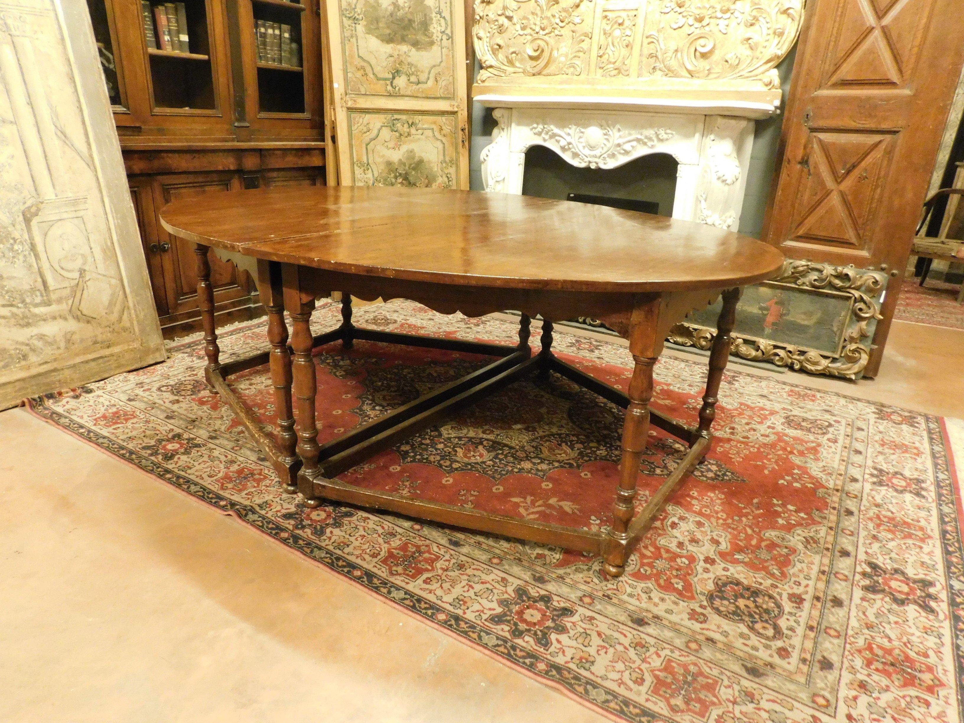 Très ancienne table ovale en bois de hêtre précieux, composée de 2 parties, divisible en 2 demi-lunes et avec 8 pieds sculptés à la main avec des motifs de l'époque, fabriquée au 17ème siècle, pour un palais noble en Italie.
Elle peut être utilisée