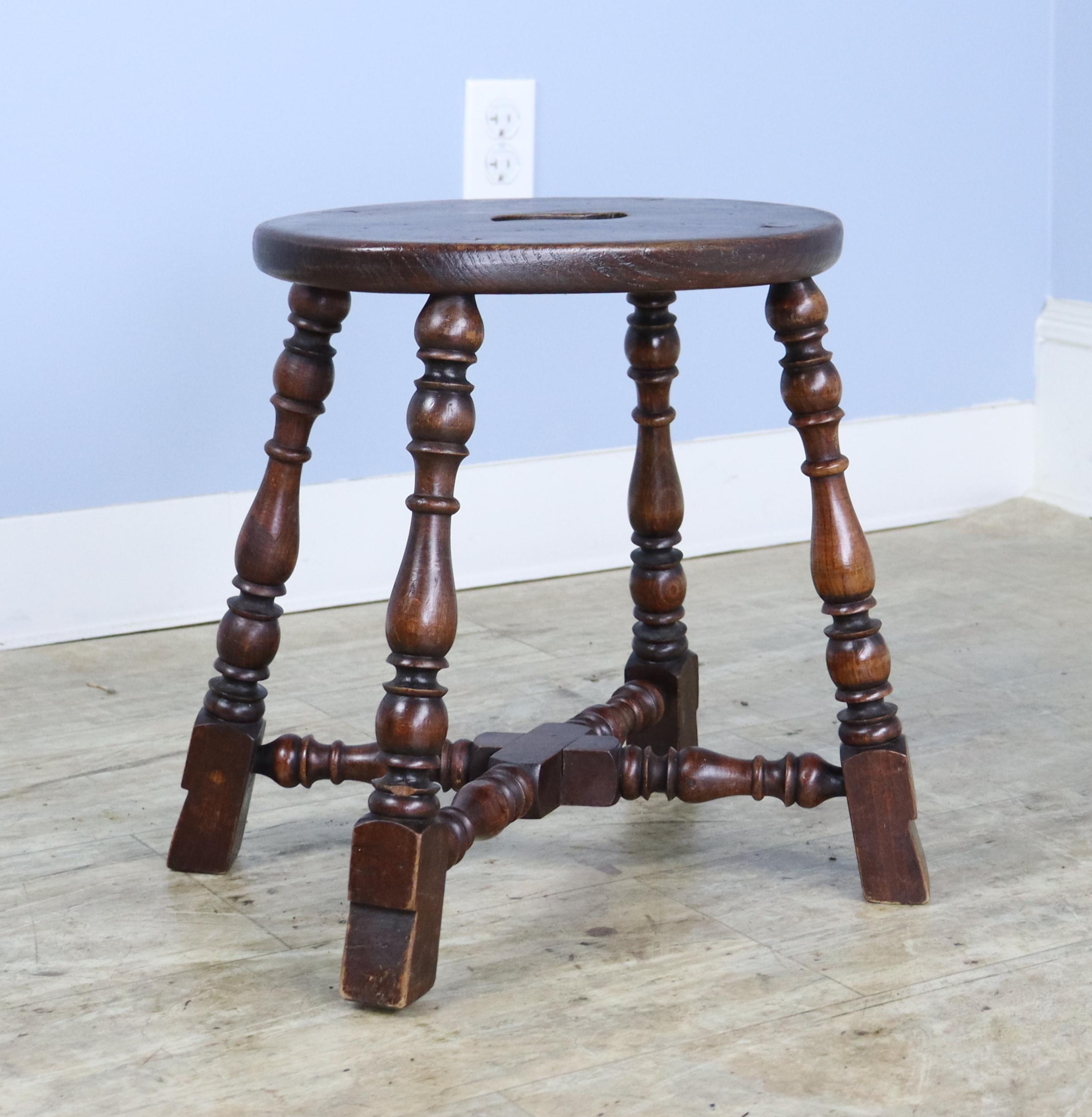 A small oval oak tavern stool with charming turned legs.  