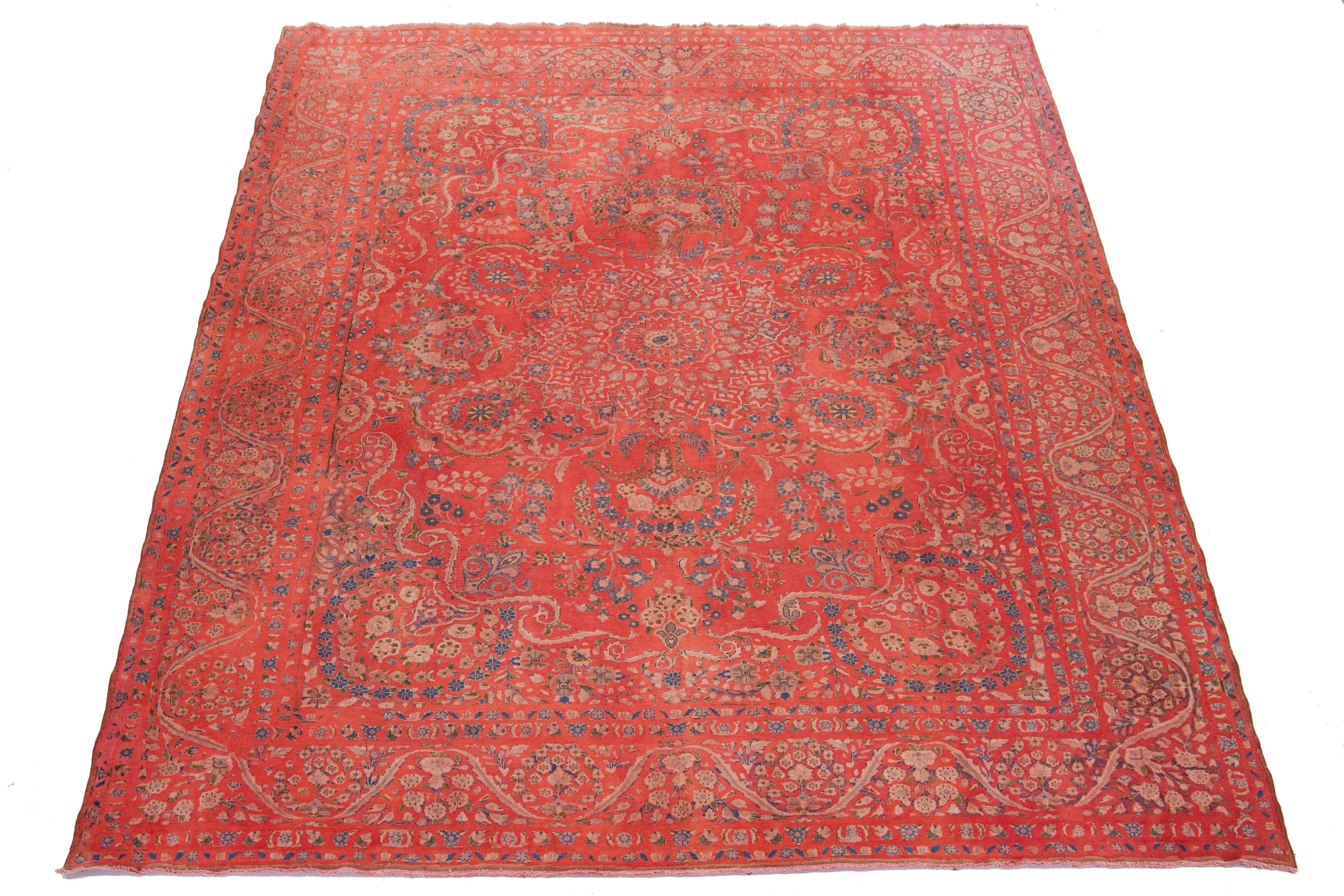 This antique red  Overdyed Persian wool rug features a rosette design with blue, beige, and green accents.

This rug measures 9'10'' x 13'.