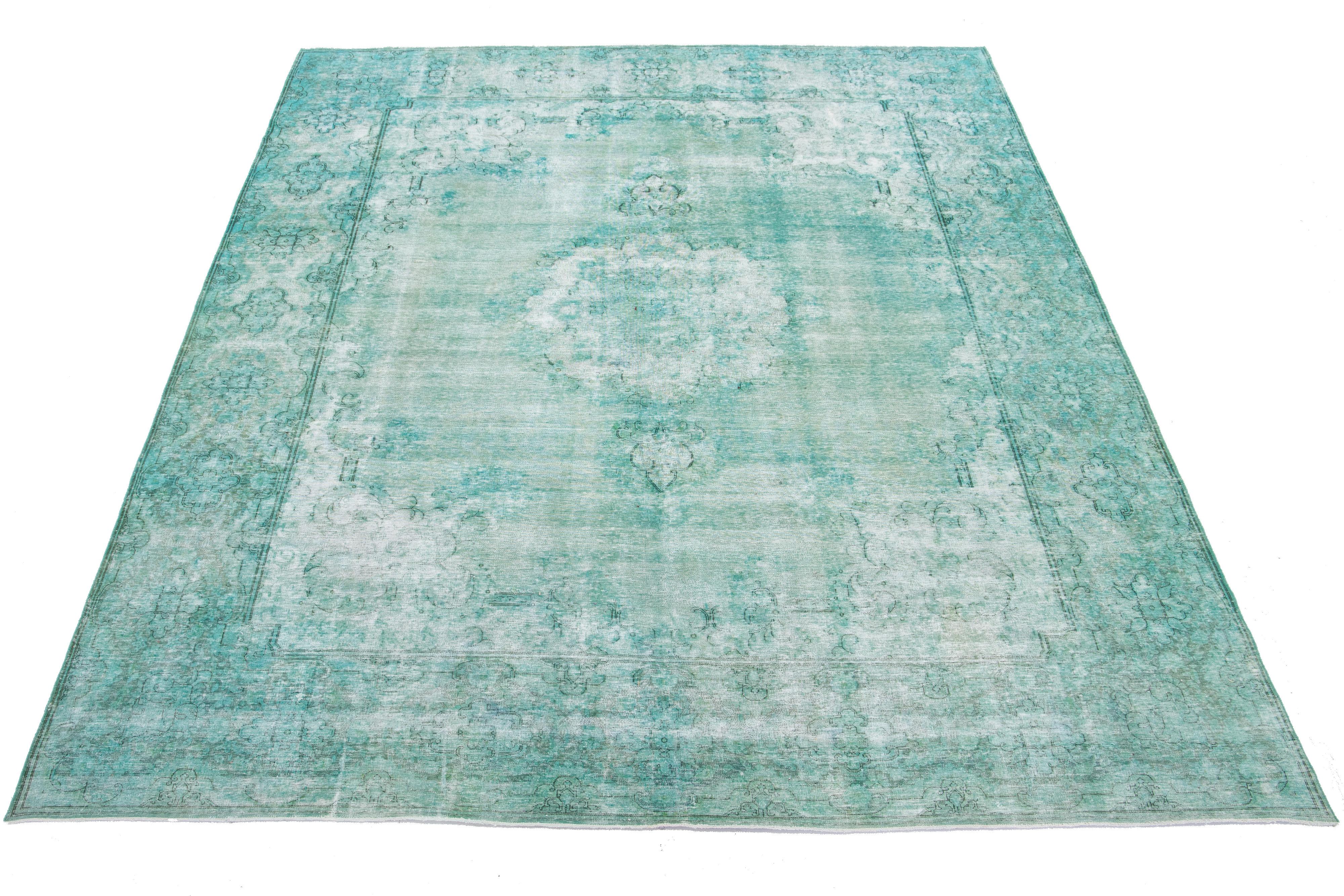 This is an antique hand-knotted wool Persian rug with a light green field. It features a medallion floral design with gray accents.

This rug measures 9'6'' x 13'3