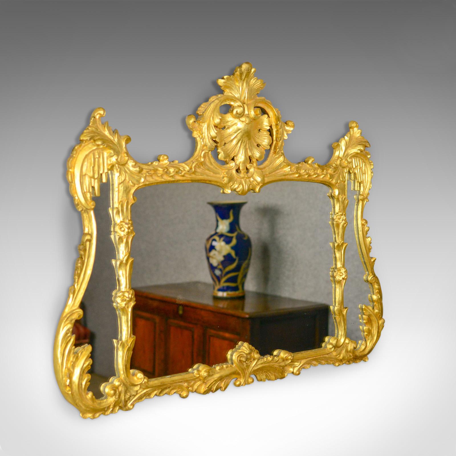 This is an antique overmantel mirror. An English, giltwood wall mirror divided as with a triptych and dating to circa 1920.

Attractive mellow golden tones in the giltwood frame
A quality piece in the Regency taste
Mid-sized and in good