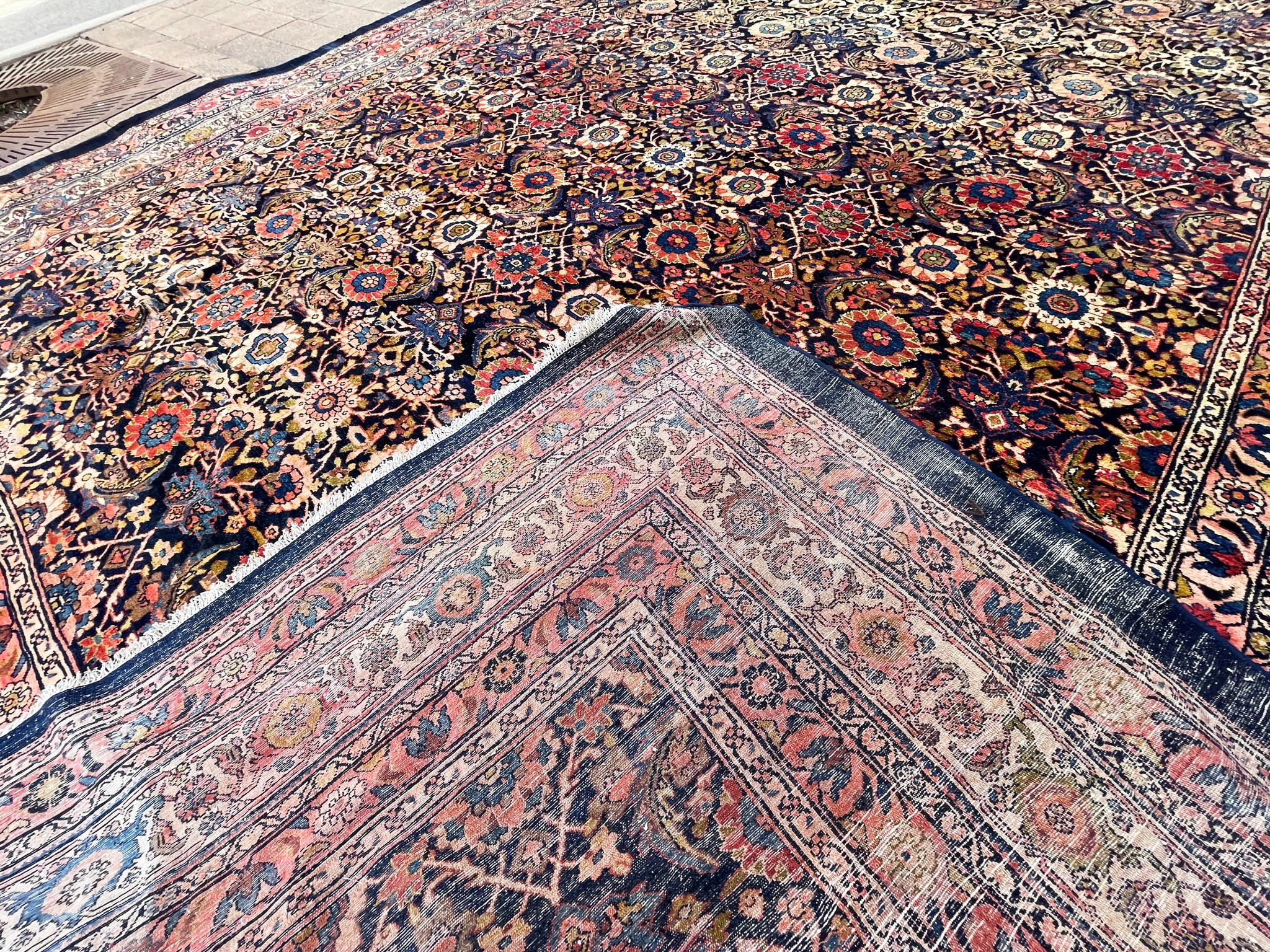 Step into the allure of history with this magnificent over-sized antique Persian Malayer carpet, measuring an impressive 11'6