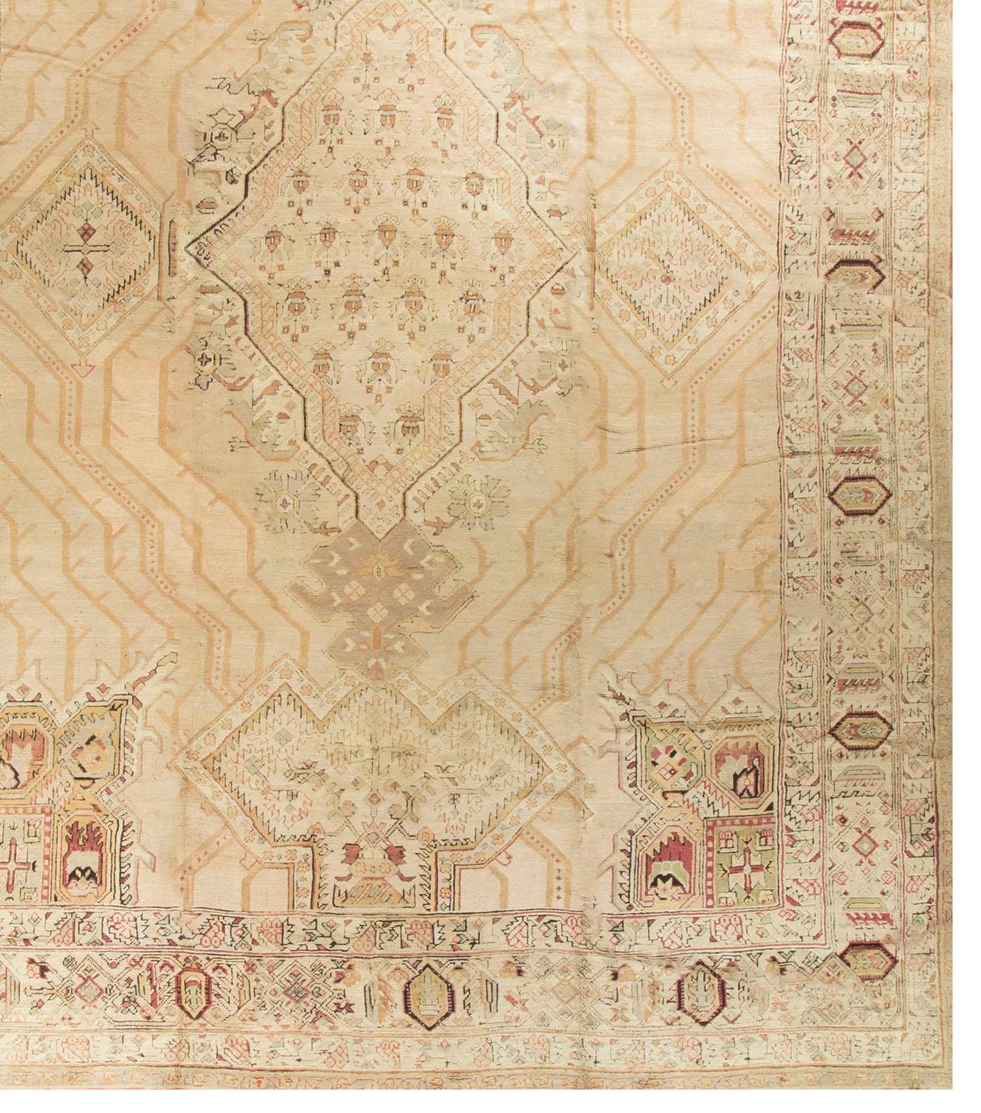 The soft colors in this oversize antique Oushak rug create a harmony with the design that lends itself to a wide variety of different room settings. Peaceful and tranquil are the words that come to mind.