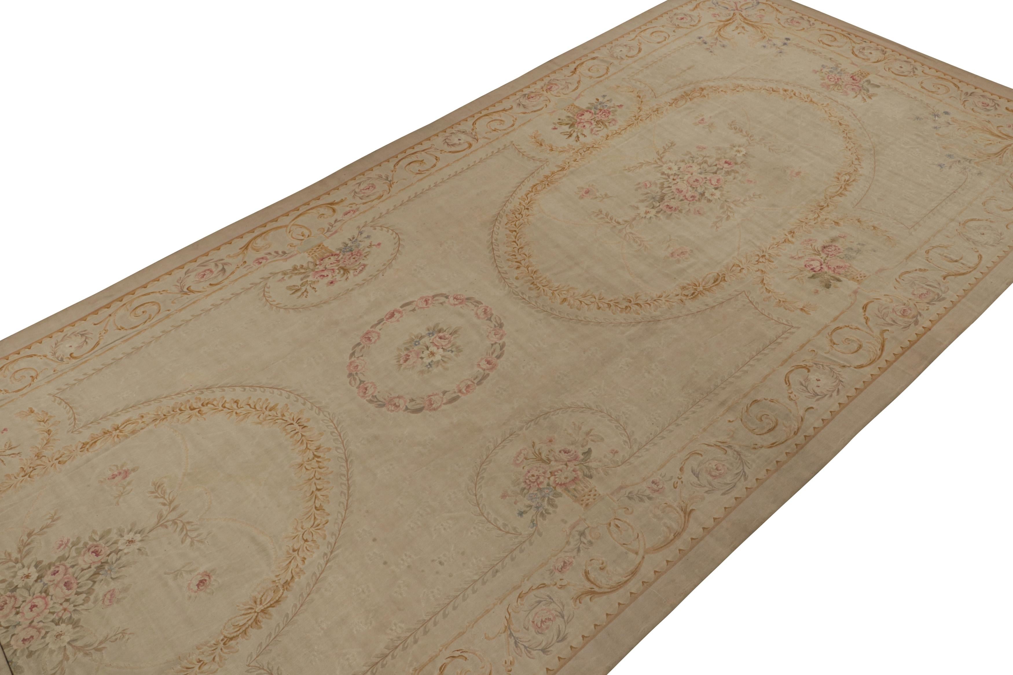 Handwoven in wool, this 10x26 antique Aubusson flatweave rug is an extremely rare oversized gallery runner from turn–of-the-century France. Its design favors beige and taupe undertones, with elegant medallions and floral patterns in the French