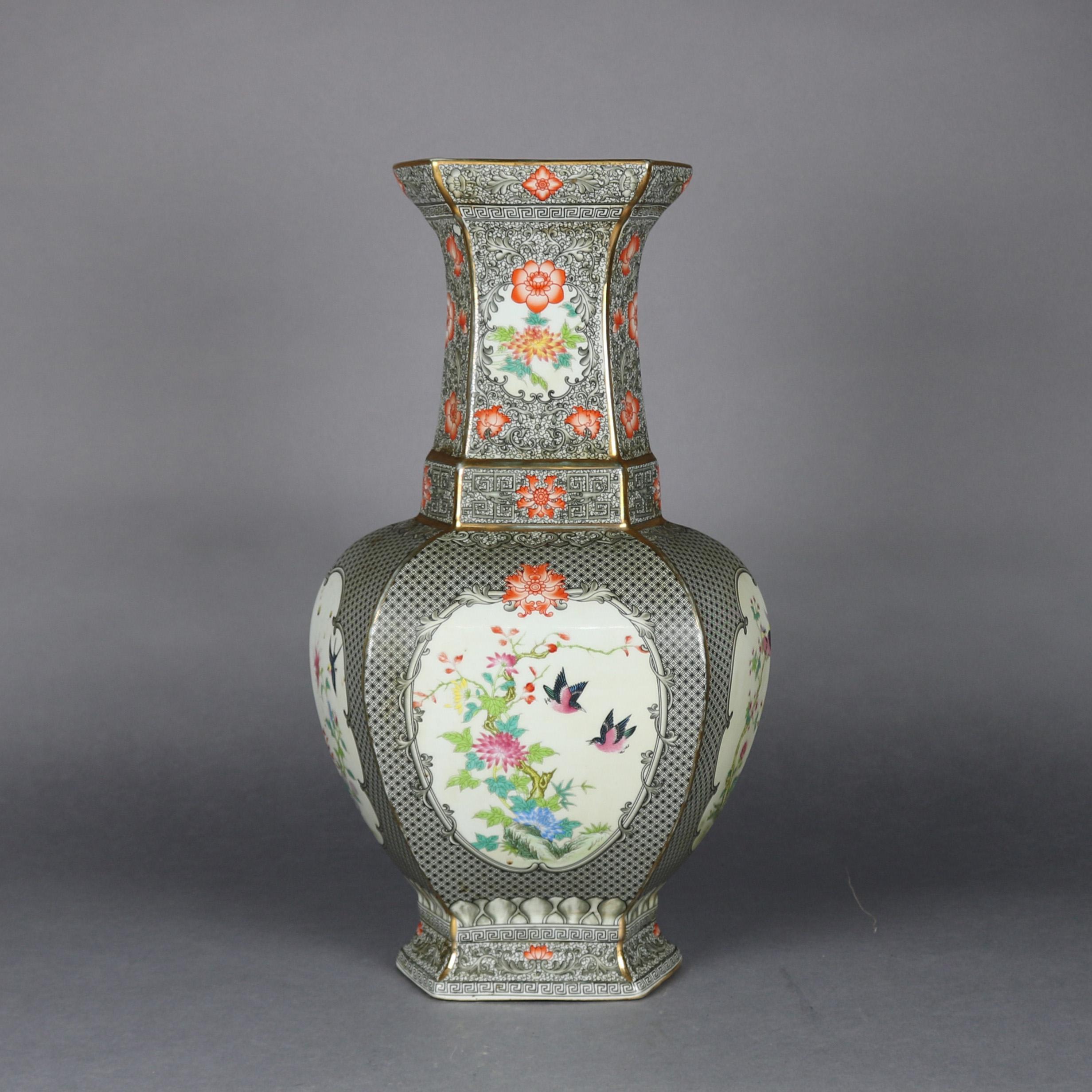 An antique oversized Chinese export porcelain vase features faceted bulbous form with all-over diaper decoration with hand painted reserves of garden scenes including flowers and birds, Greek Key bordering throughout, signed on base, 19th