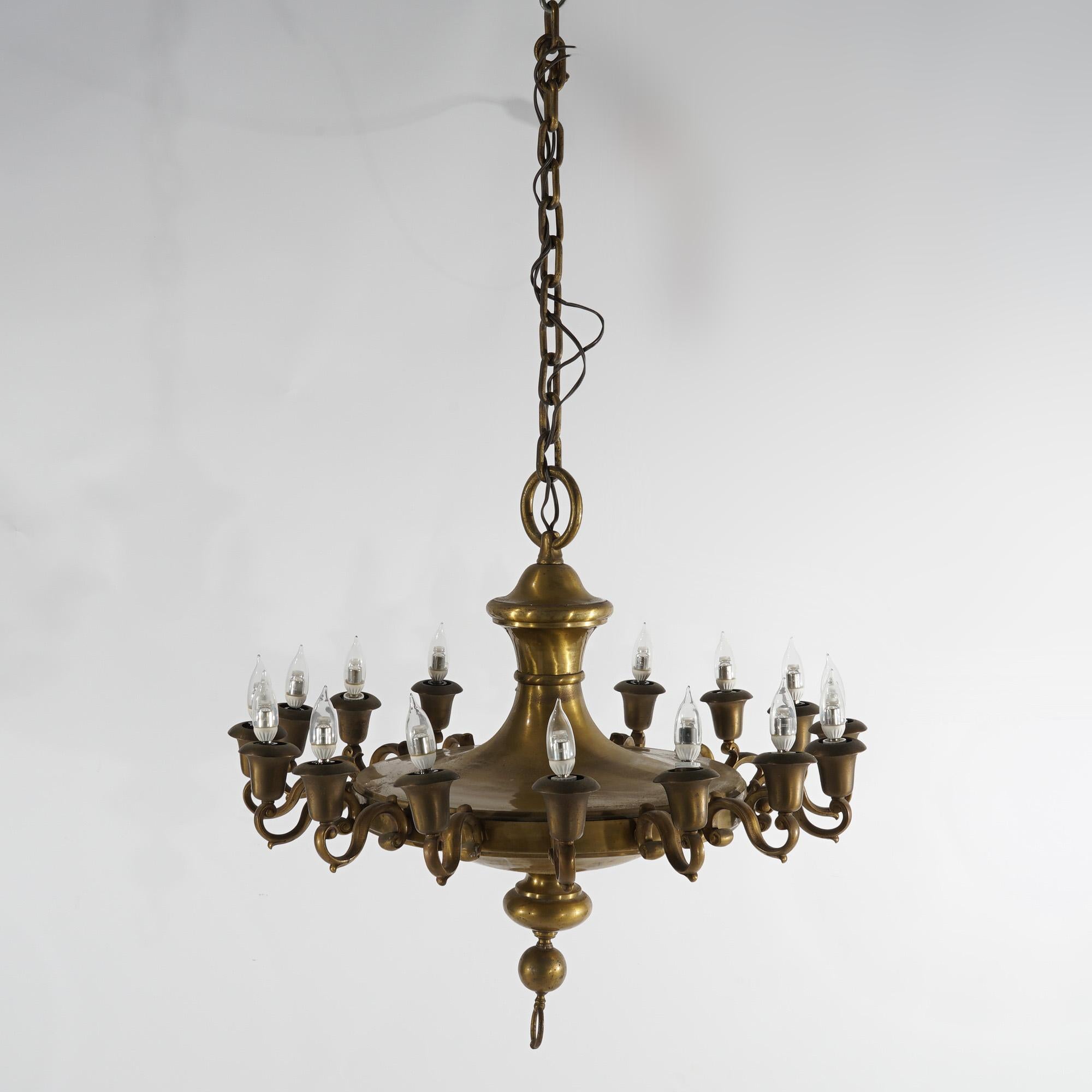 An antique and large French Empire style pan chandelier offers brass construction with sixteen scroll form arms terminating in lights, ebonized elements, c1930

Measures - 53