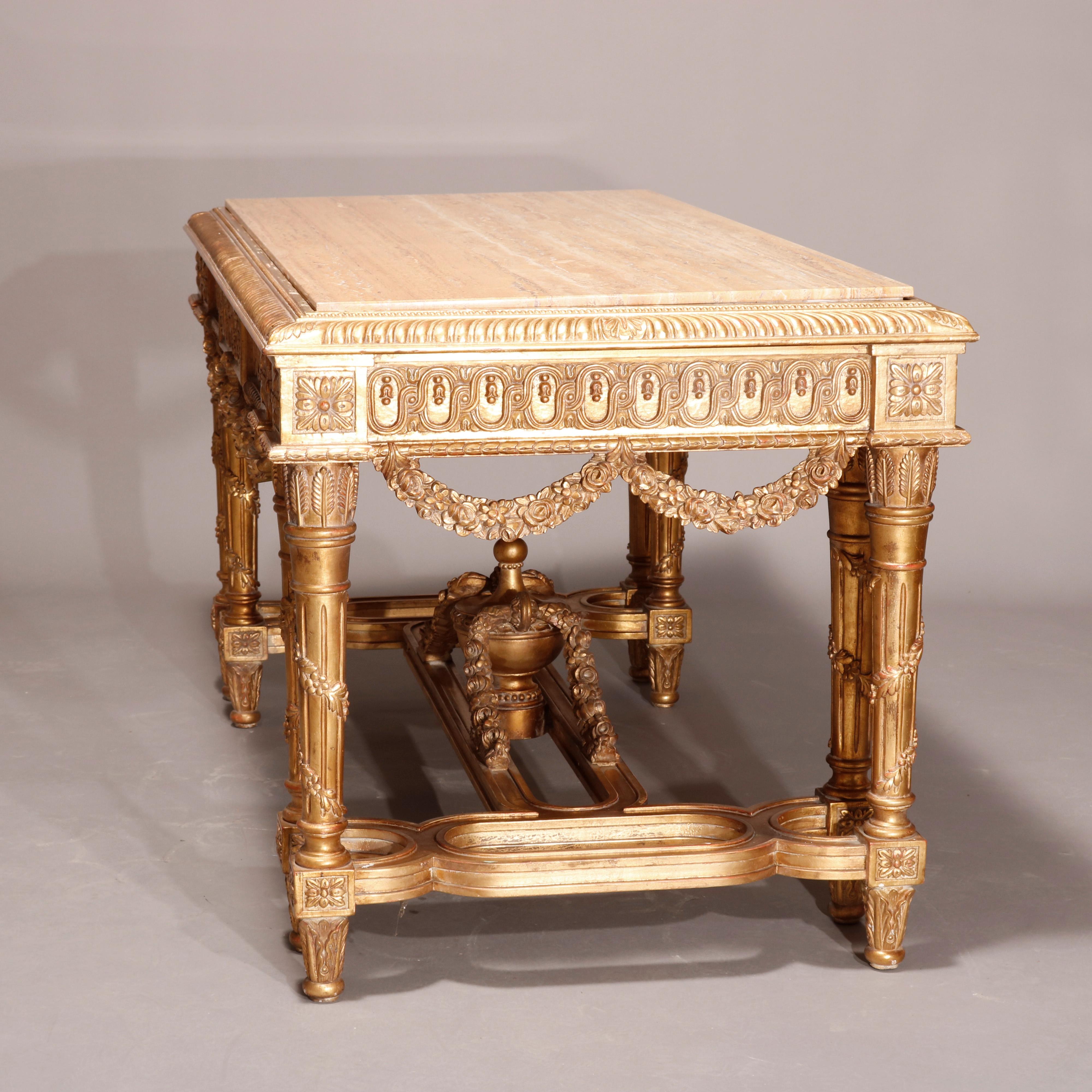 An antique monumental French Empire style parlor table offers marble top surmounting highly ornate giltwood base having gadroon trimming over decorated skirt having floral garland swags, rosettes, and raised on reeded and tapered double legs having