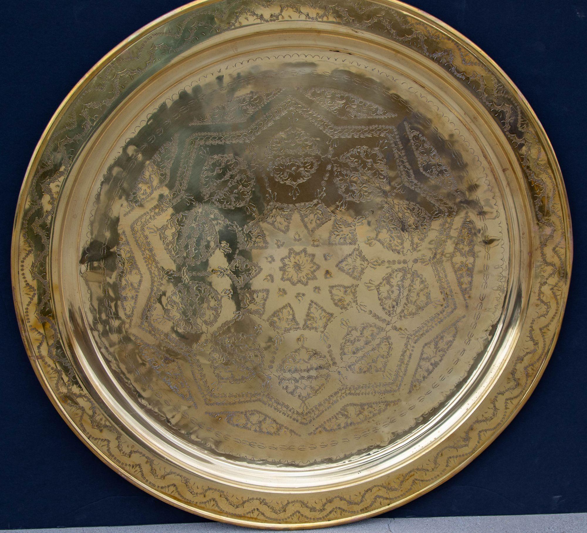 Antique 19th century oversized round shape Moroccan polished metal brass tray platter. 
Polished decorative metal round brass tray with very fine intricate geometric Moorish Islamic designs. 
Hand-hammered and chiseled in floral and geometric