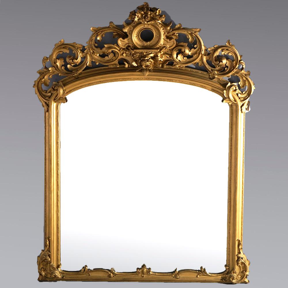 An antique and large Victorian over mantel mirror offers giltwood frame with foliate carved crest over mirror with acanthus elements, 19th century

Measures- 81'' H x 63'' W x 11.5'' D.