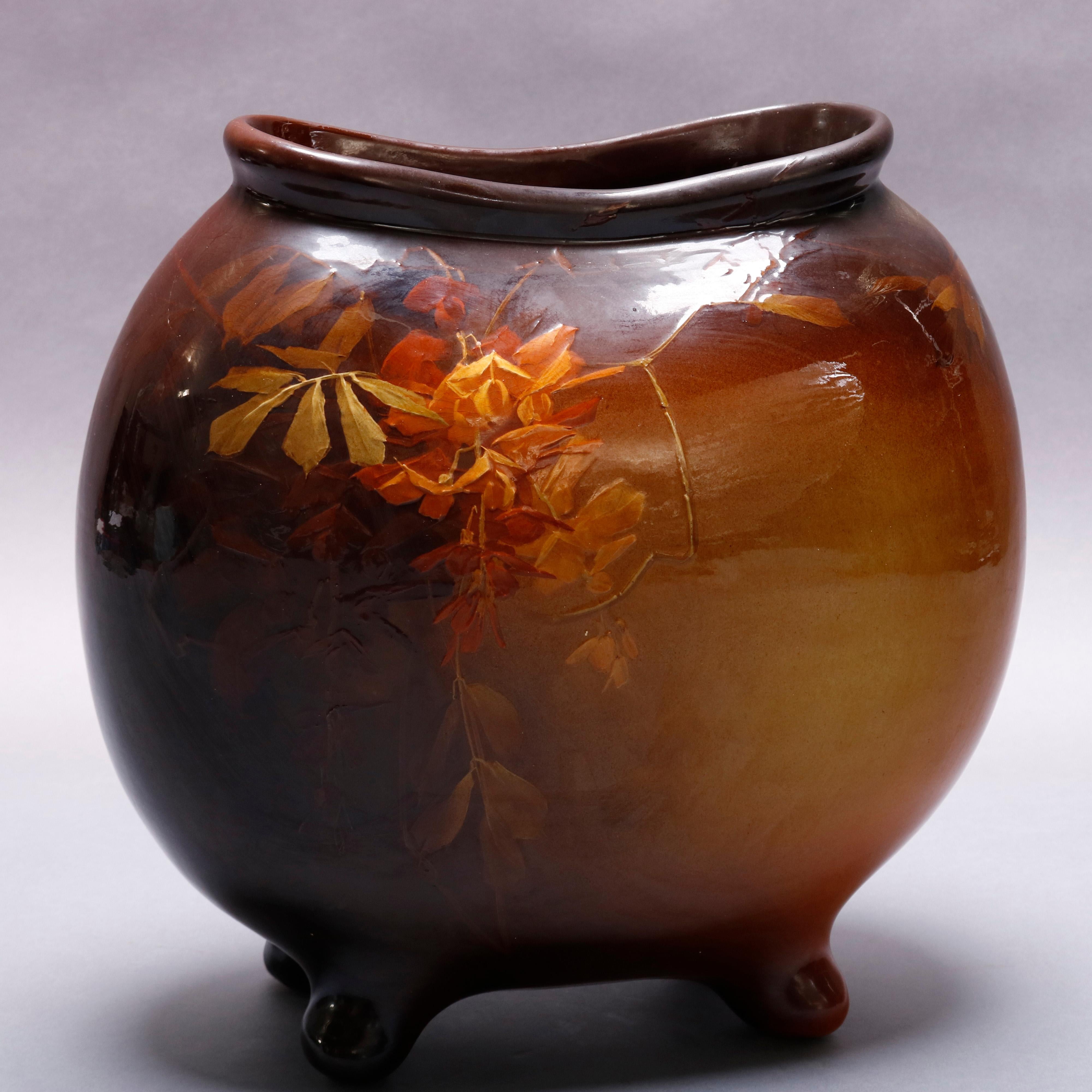 An antique Owens art pottery vase offers footed pillow form hand decorated in Utopian Floral decoration, reminiscent of Weller, Owens Pottery maker stamp on base, circa 1920

Measures: 12