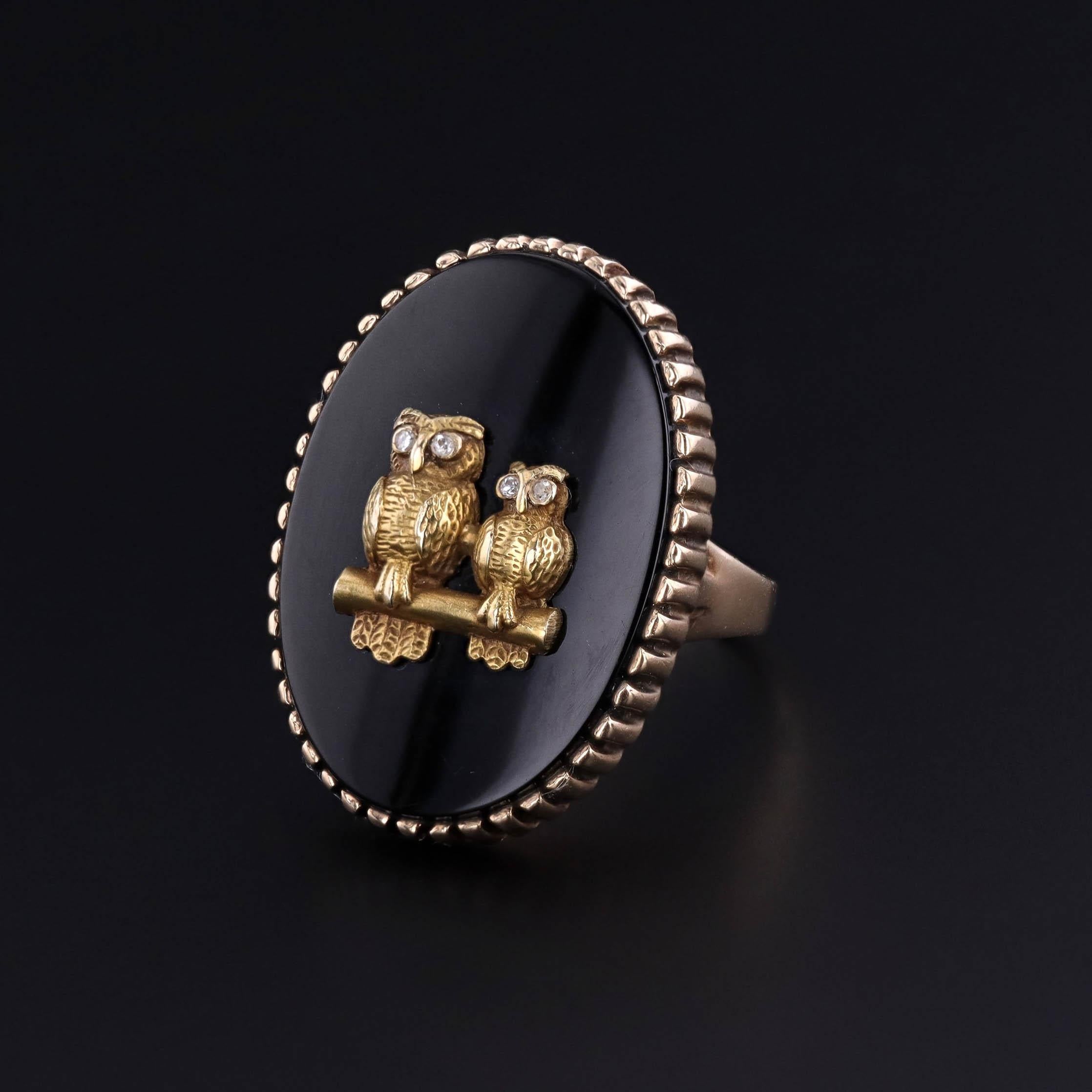 Mid 20th Century Statement Ring – Onyx with Diamond-Eyed Gold Owls in 10k Gold: This striking statement ring showcases a captivating design featuring two intricately crafted gold owls perched on a branch. The owls, with their diamond eyes, are set