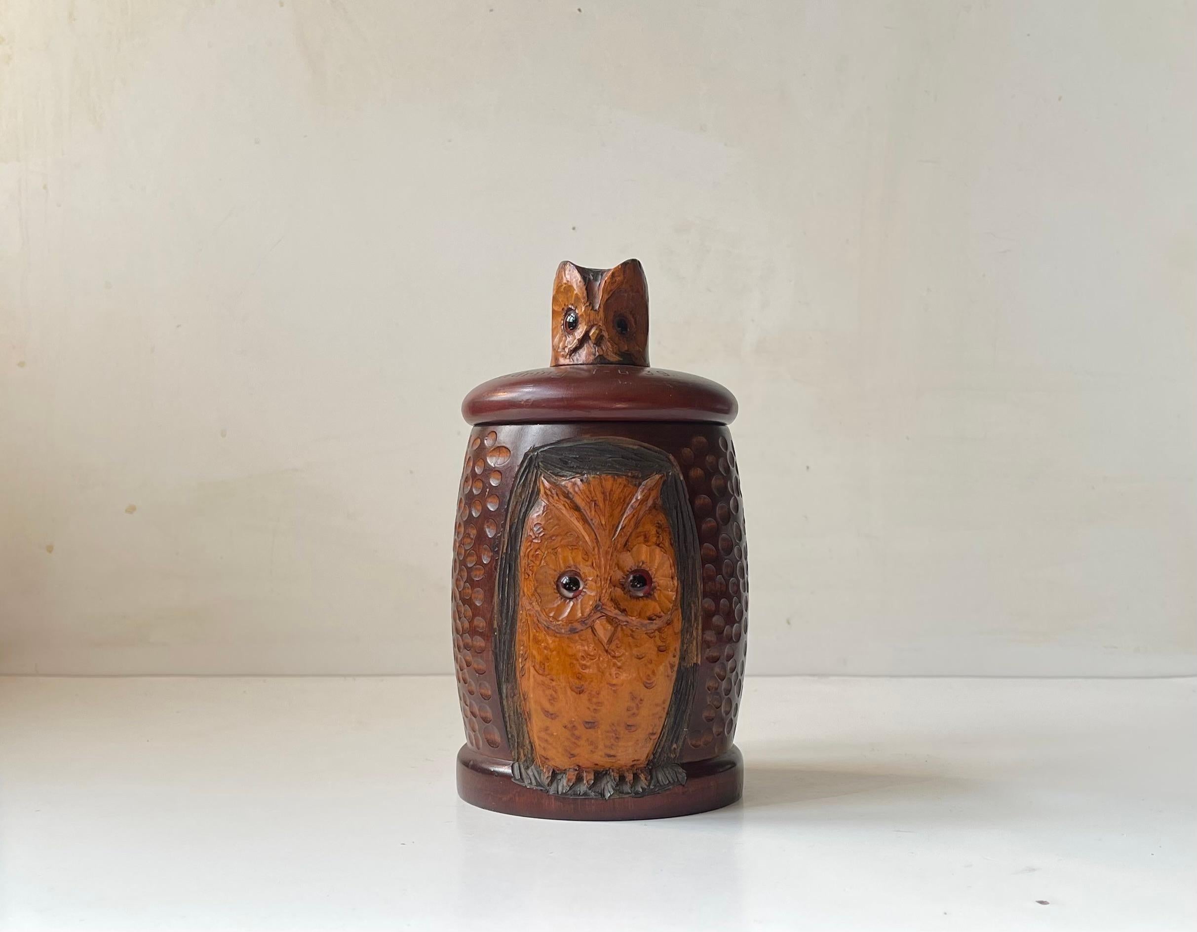 Unusual tea caddy in hand-carved stained/colored/lacquered oak. Its main 'body' is carved from one piece and features an adult owl carved in Relief. The lid is carved with its offspring. Both owl has matching brown glass eyes. Given as a