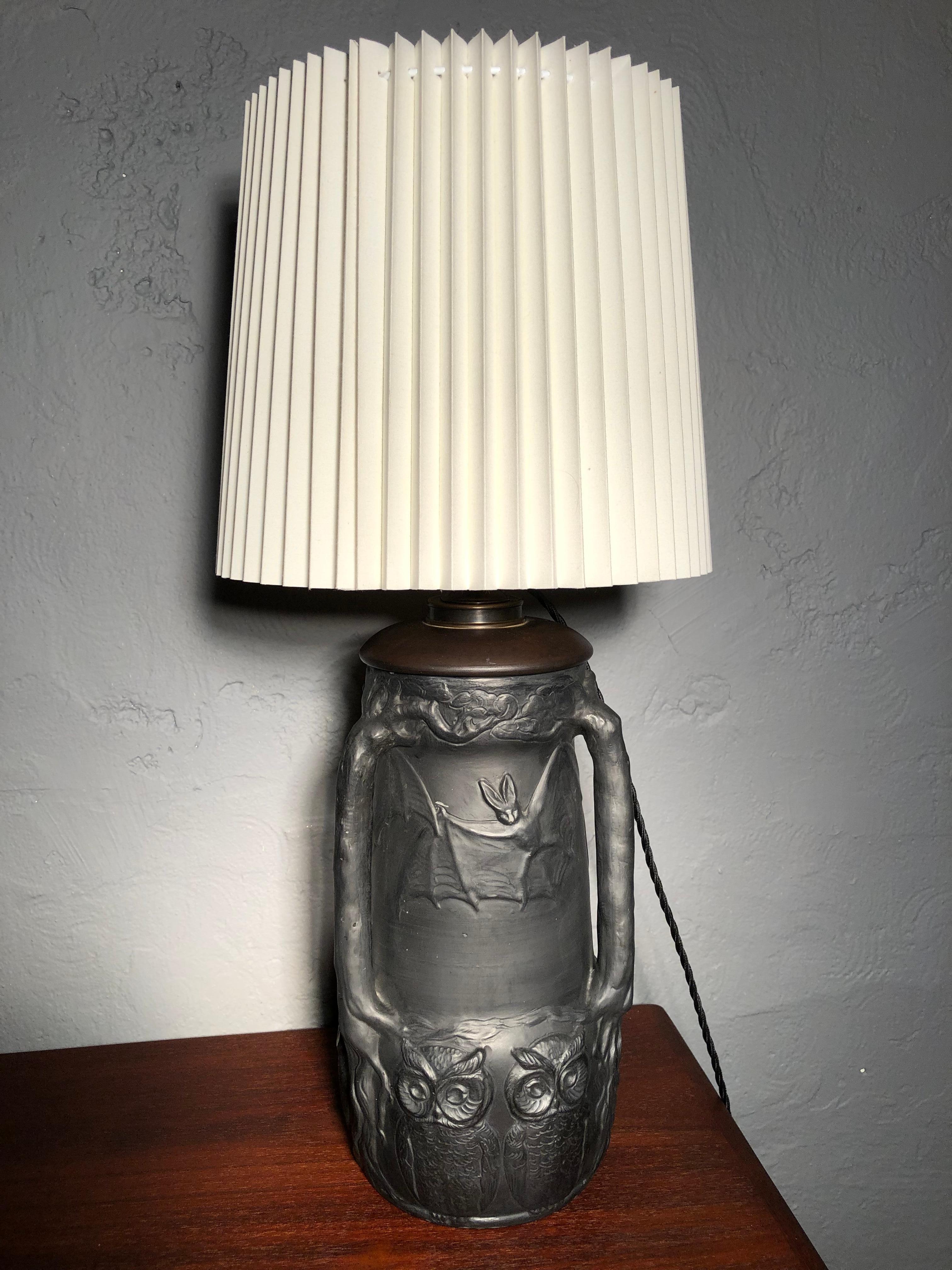 An amazing black pottery table lamp with owls and bats by Lauritz Adolph Hjorth of Bornholm Denmark. 
Originally an oil lamp with an early conversion to electricity. 
Still with the original brass and porcelain lamp holder. 
Has been rewired with a