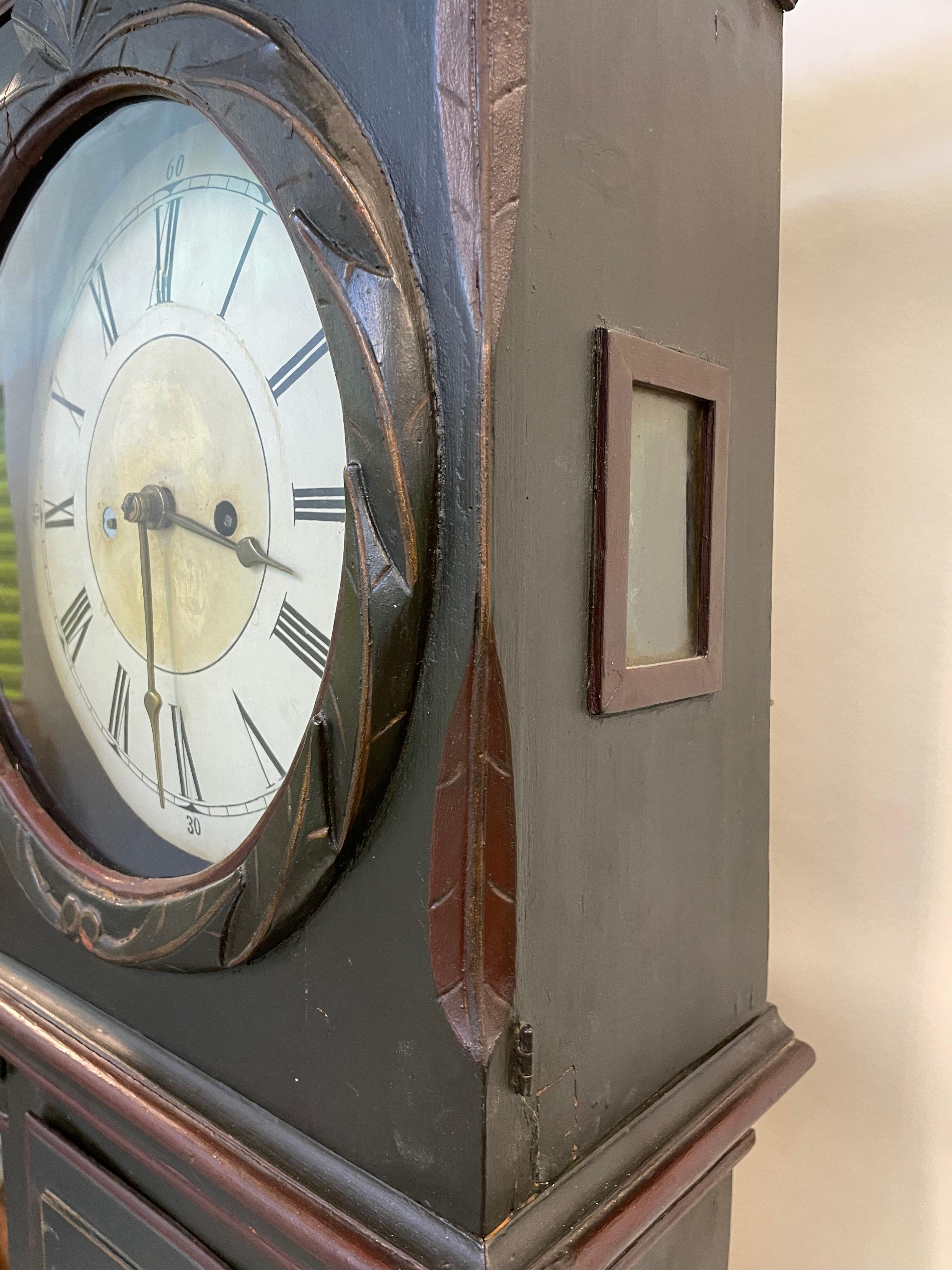 This stately grandfather clock is from the first quarter of the 19th century. It is made in the traditional Scandinavian style of clock making and has charming and whimsical details on the face of the clock as well as filigreed wooden side access