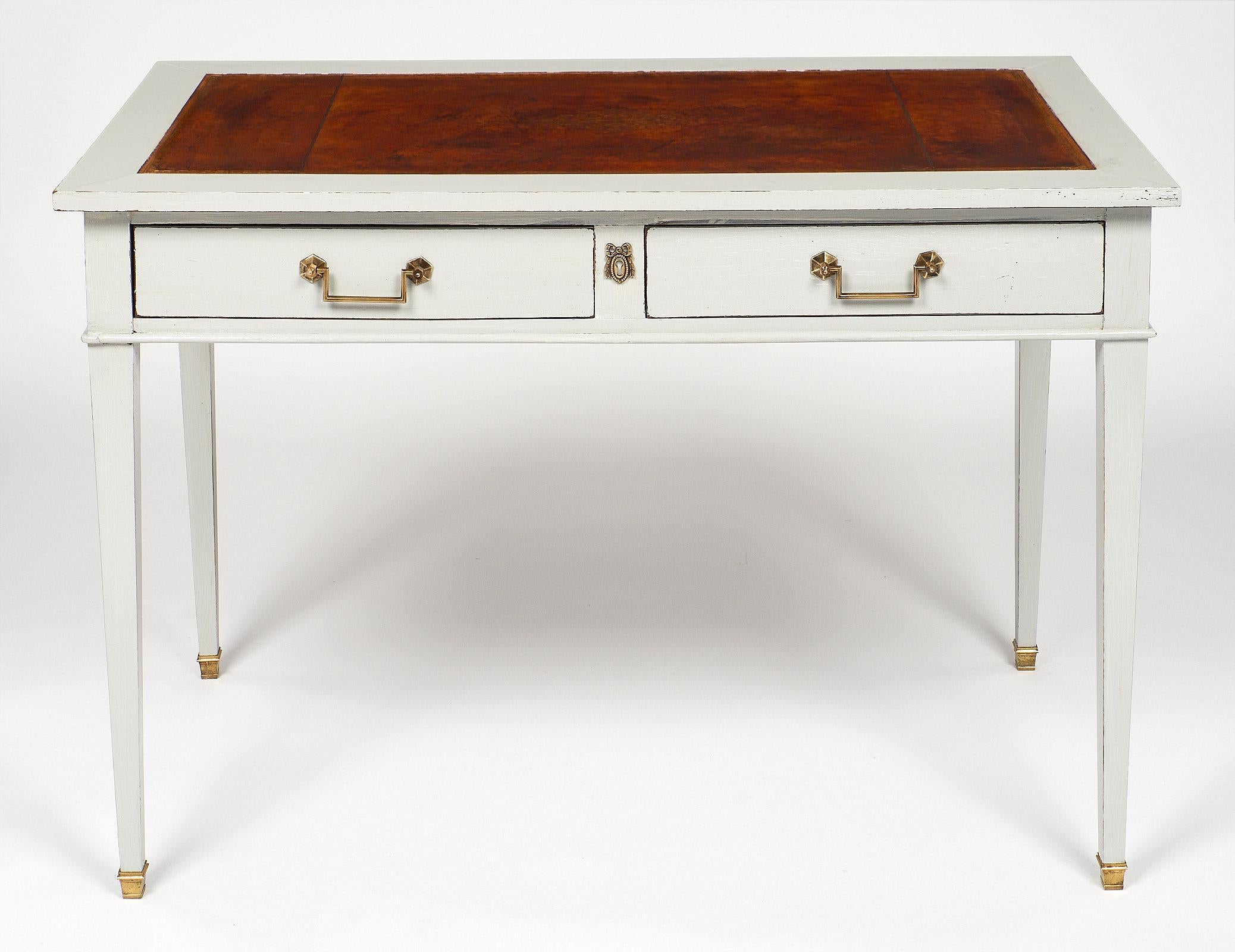 French Directoire style antique painted writing desk in a “Trianon” gray color. A waxed Moroccan leather top embossed with a gilded frieze, and two pull-out extensions complete the writing surface. We love the squared and tapered legs, brass