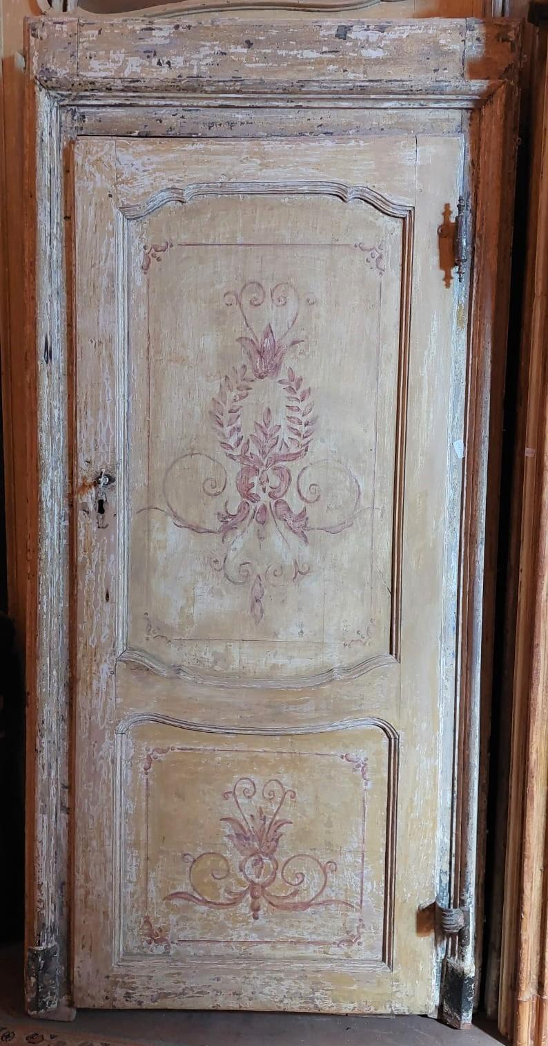 Antique interior door, lacquered and hand painted, with red floral motifs on a yellow background patinated by the centuries, complete with original frame and irons (it still has a gooseneck opening, which made the door open deliberately crooked),
