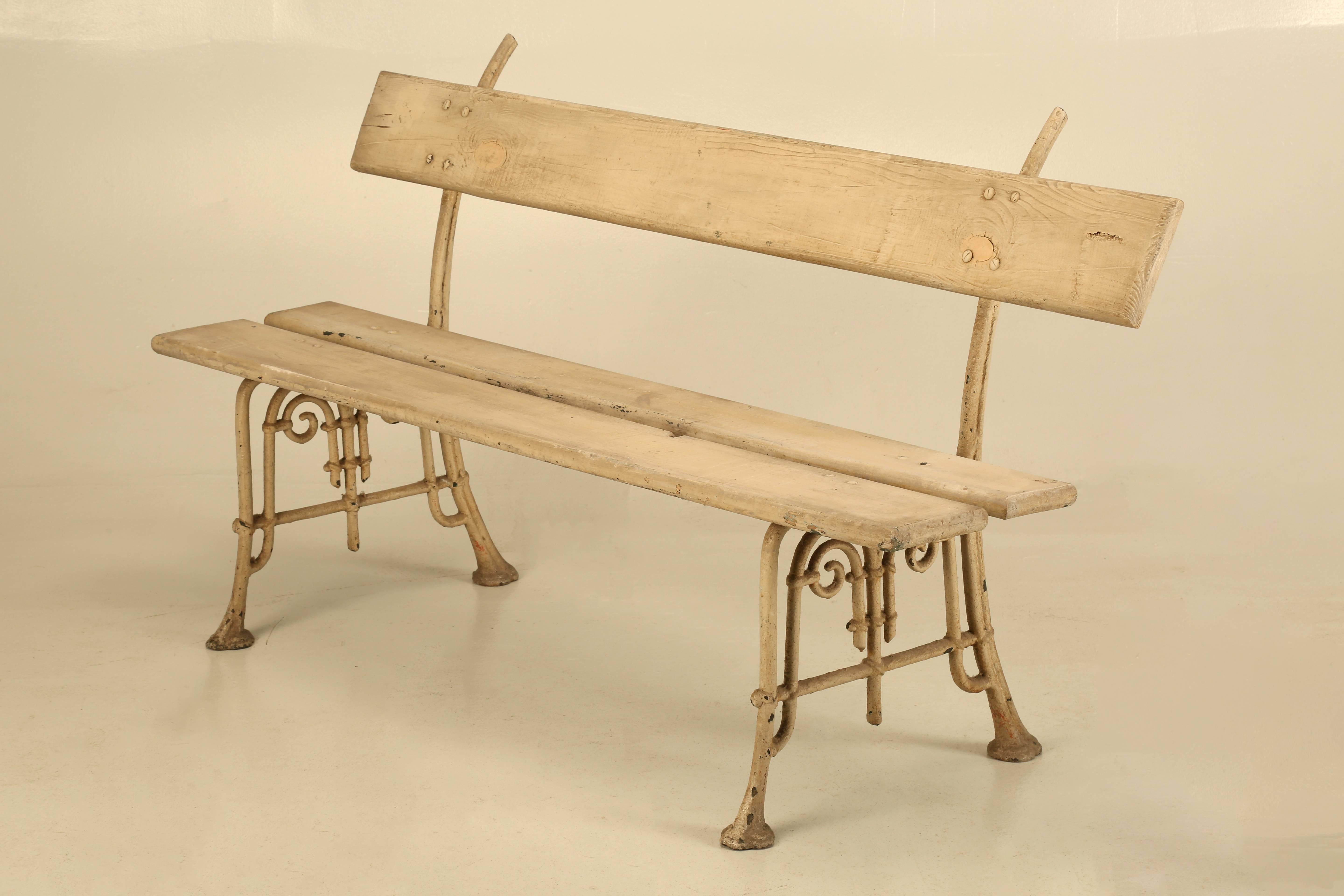Antique painted French garden bench, with cast iron supports and finished in a very light shade of grey.

 