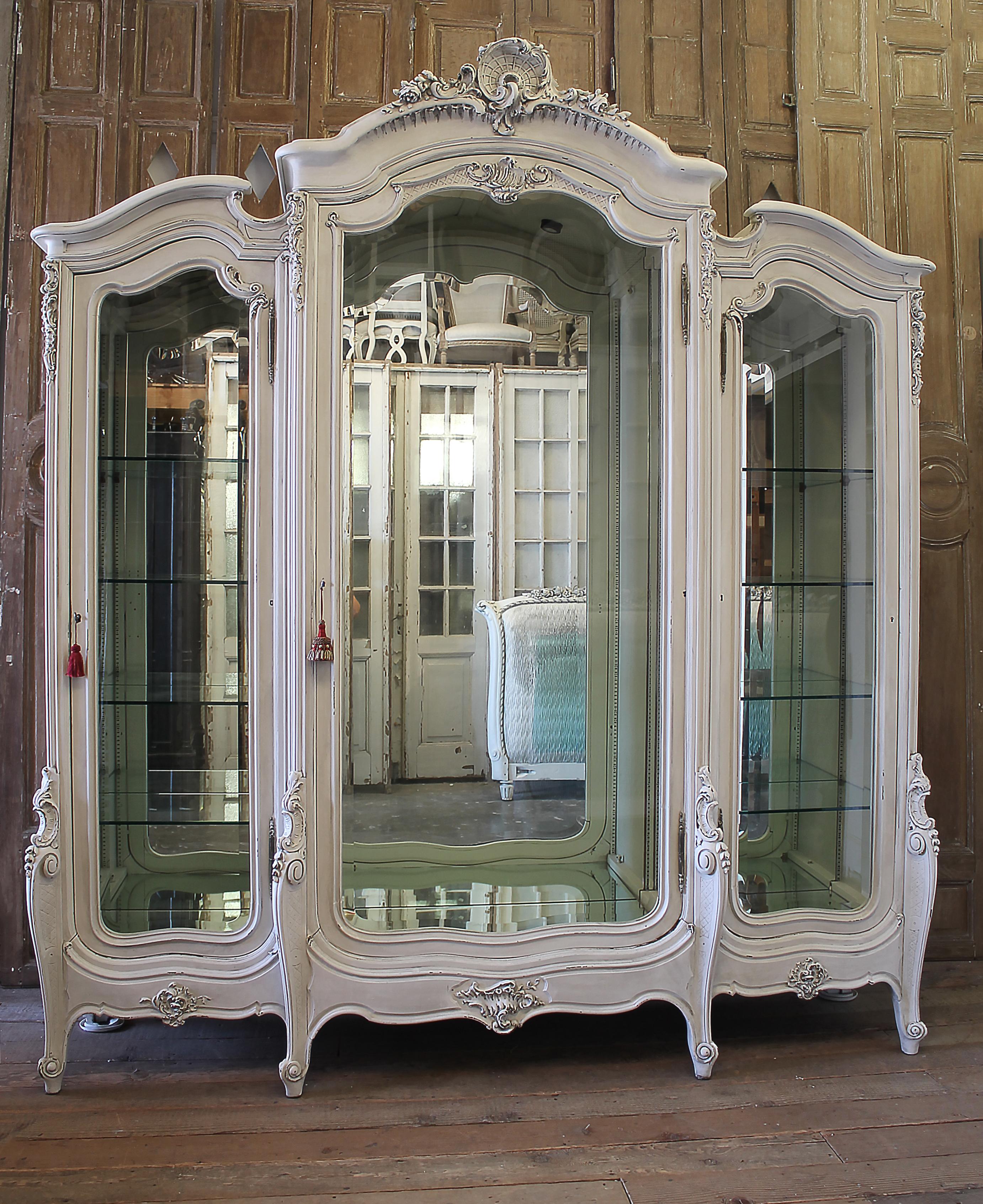 Antique Painted French Louis XV style carved display armoire
Painted in a soft white with subtle distressed edges, and antique glazed patina. Beautiful armoire for display has glass shelved in the sides that are fully adjustable. We will have 4