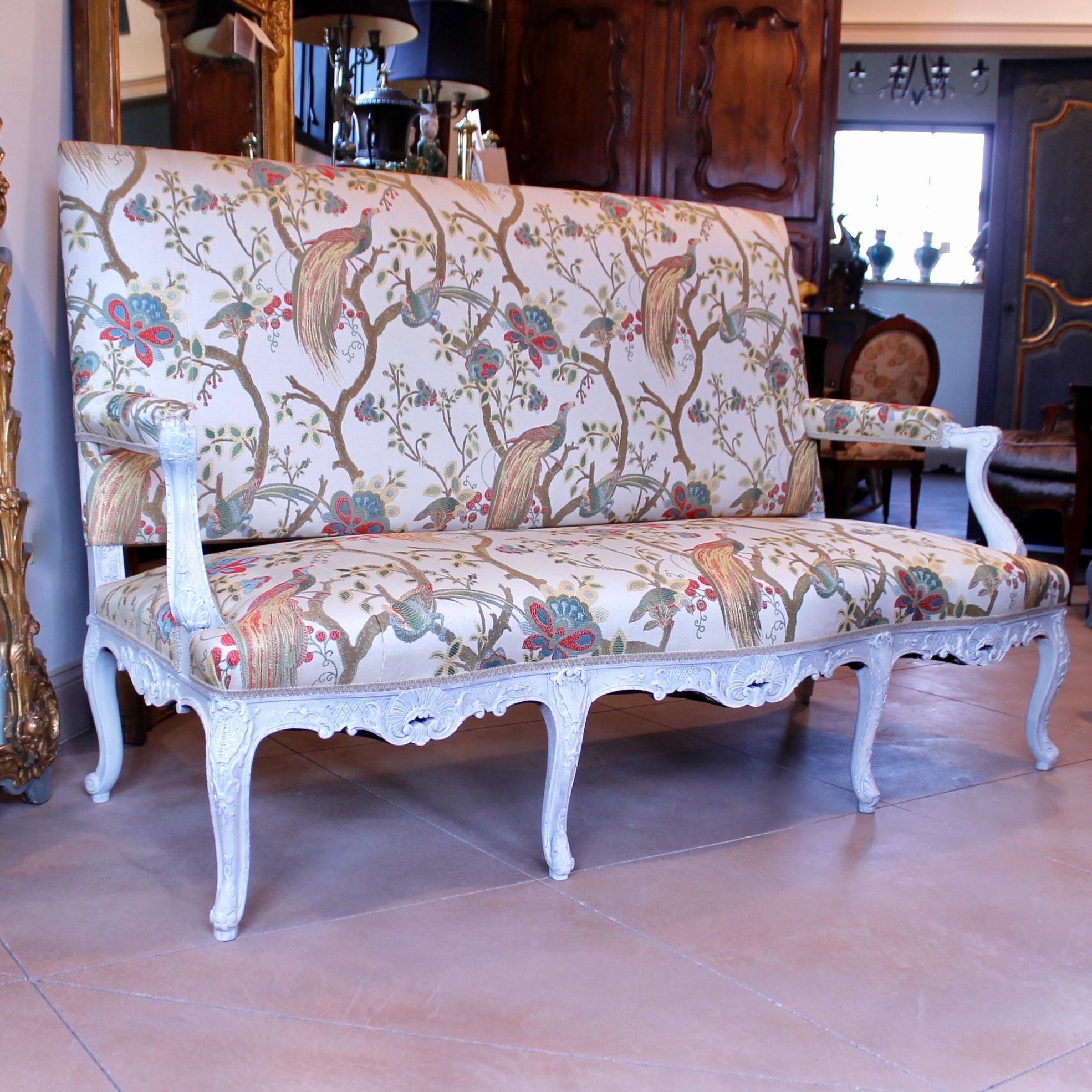 Ein sehr fein geschnitztes Sofa im Régence-Stil aus den 1890er Jahren, cremefarben lackiert und frisch gepolstert mit einem gewebten Stoff aus dem 18. Jahrhundert mit Zweigen und Fasanen. Die Schnitzerei ist scharf und sehr detailliert, und die
