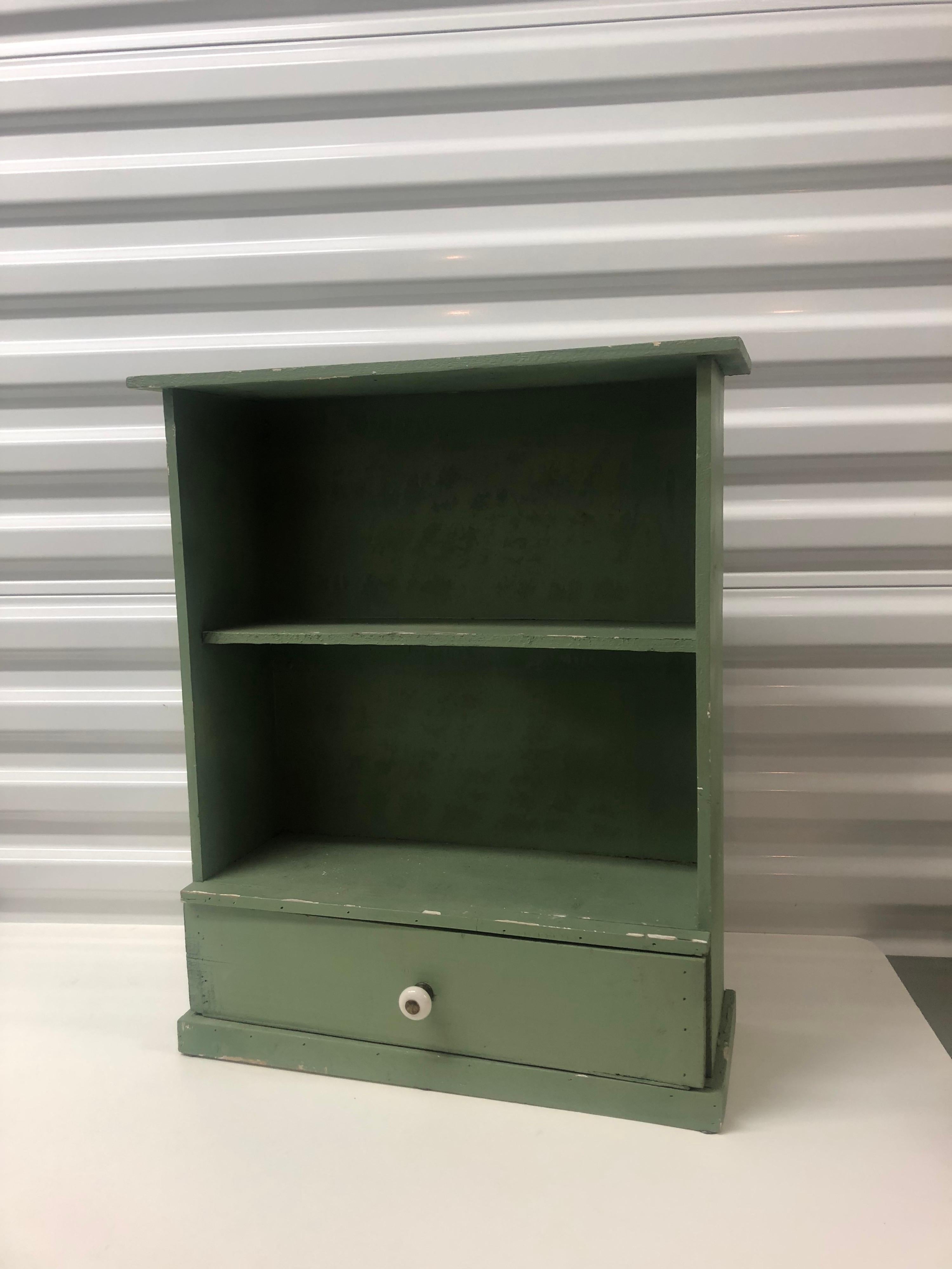 Antique painted green display wall cabinet/shelves.
with small pull out drawer and glass knob.
Chalk paint matte finish.
Size: 16.75