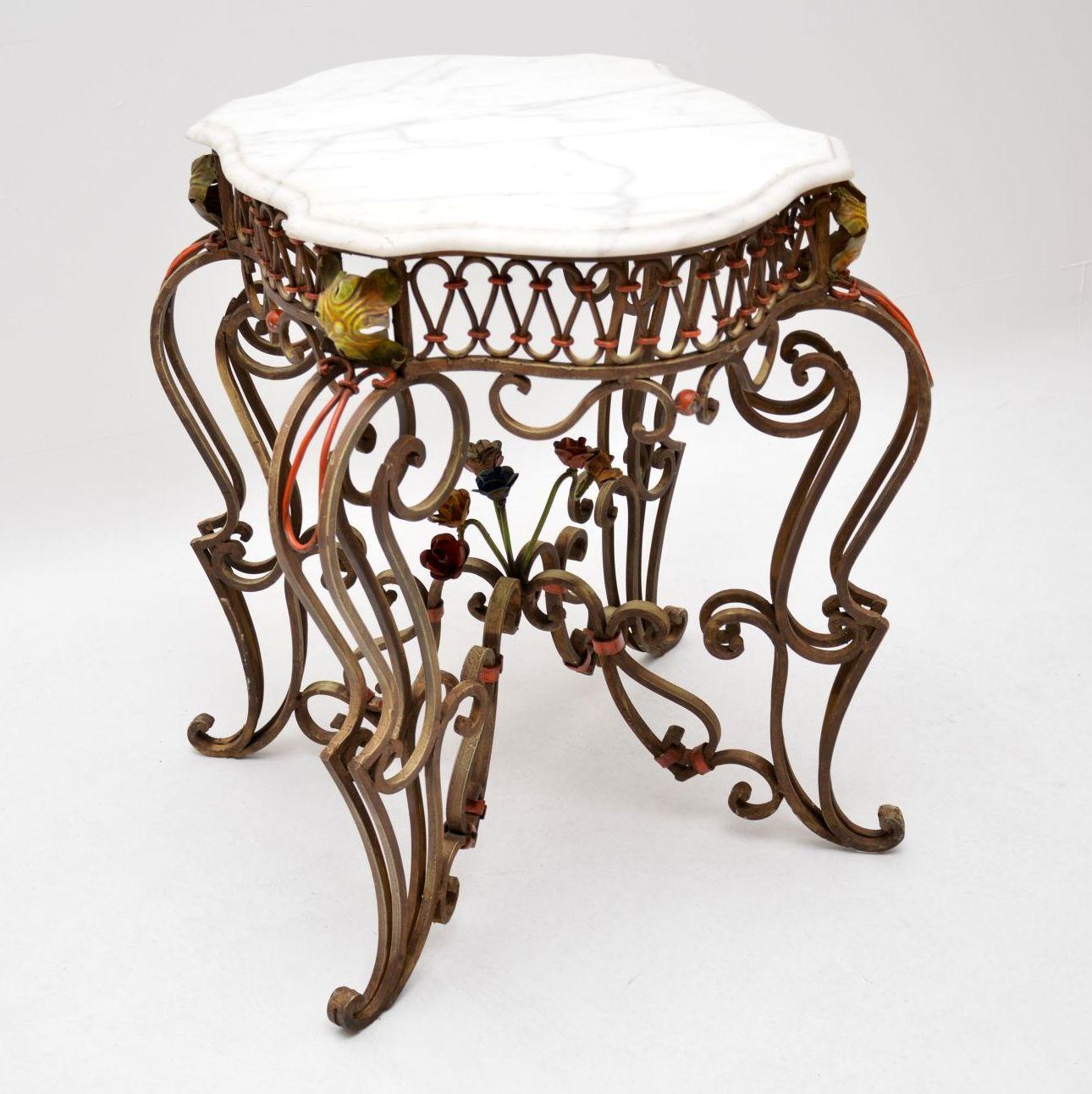 This antique marble top iron table is in excellent condition and has some wonderful features. I believe it’s French and dates to circa 1890-1910 period. The painted features are very colorful and there are various colored flowers too. It has an