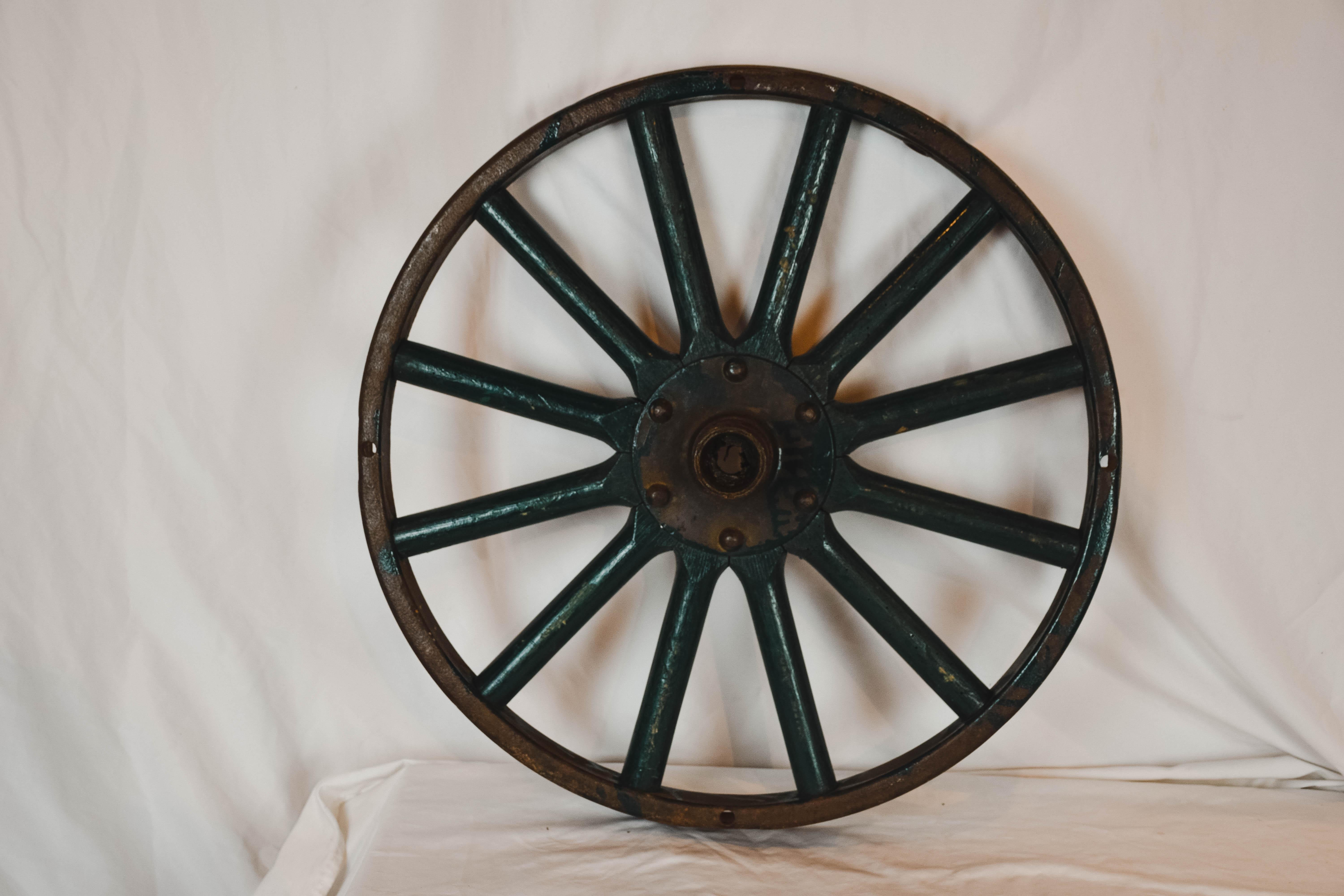 Antique painted iron wheel. This old wheel is in good vintage condition. Perfect farmhouse, ranch, garden or man-cave decor. This has two secure hooks on it for hanging. It has a great patina and look to it!

  