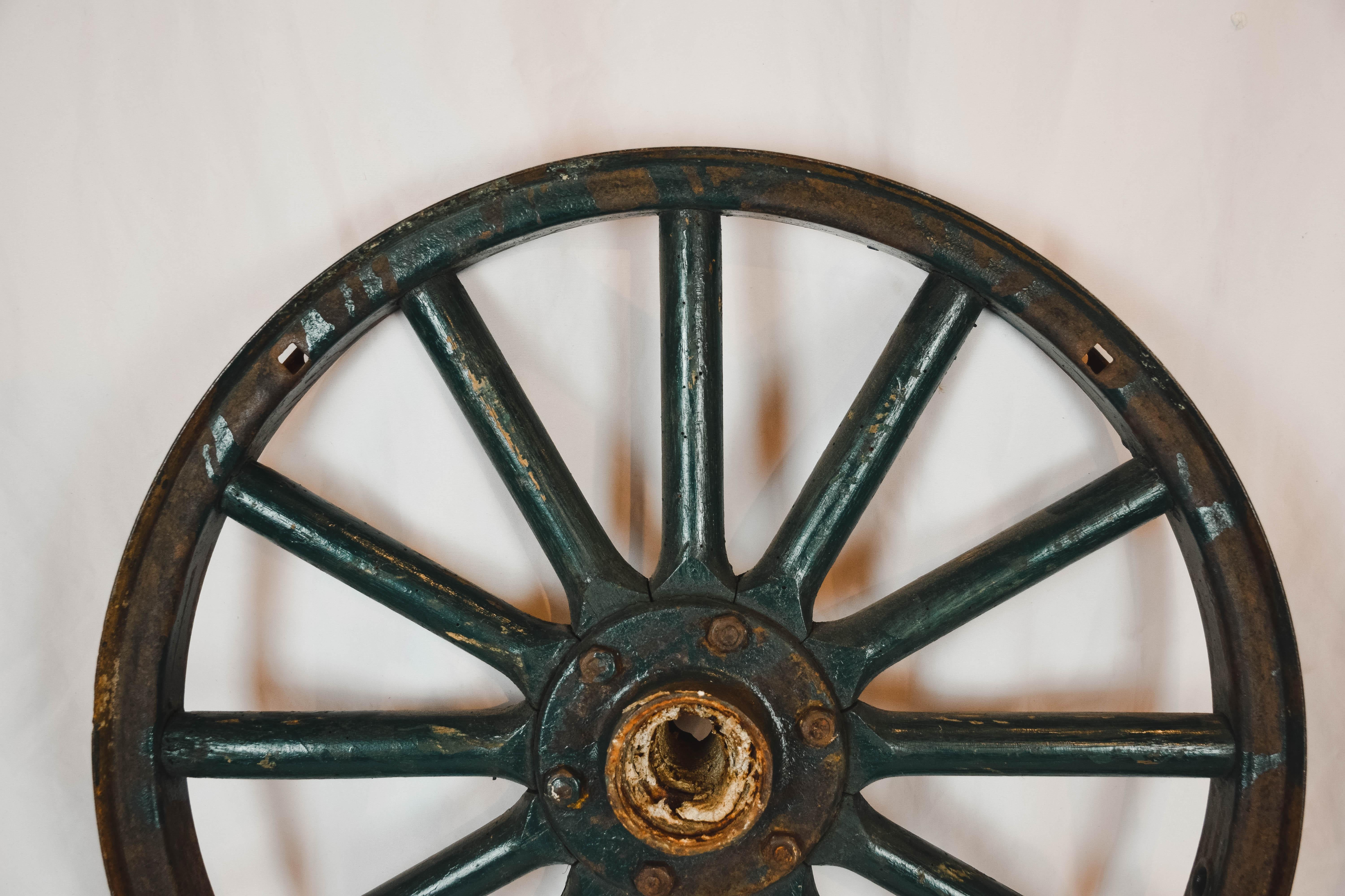 Antique painted iron wheel. This old wheel is in good vintage condition. Perfect farmhouse, ranch, garden or man-cave decor. This has two secure hooks on it for hanging. It has a great patina and look to it!

Two Available.