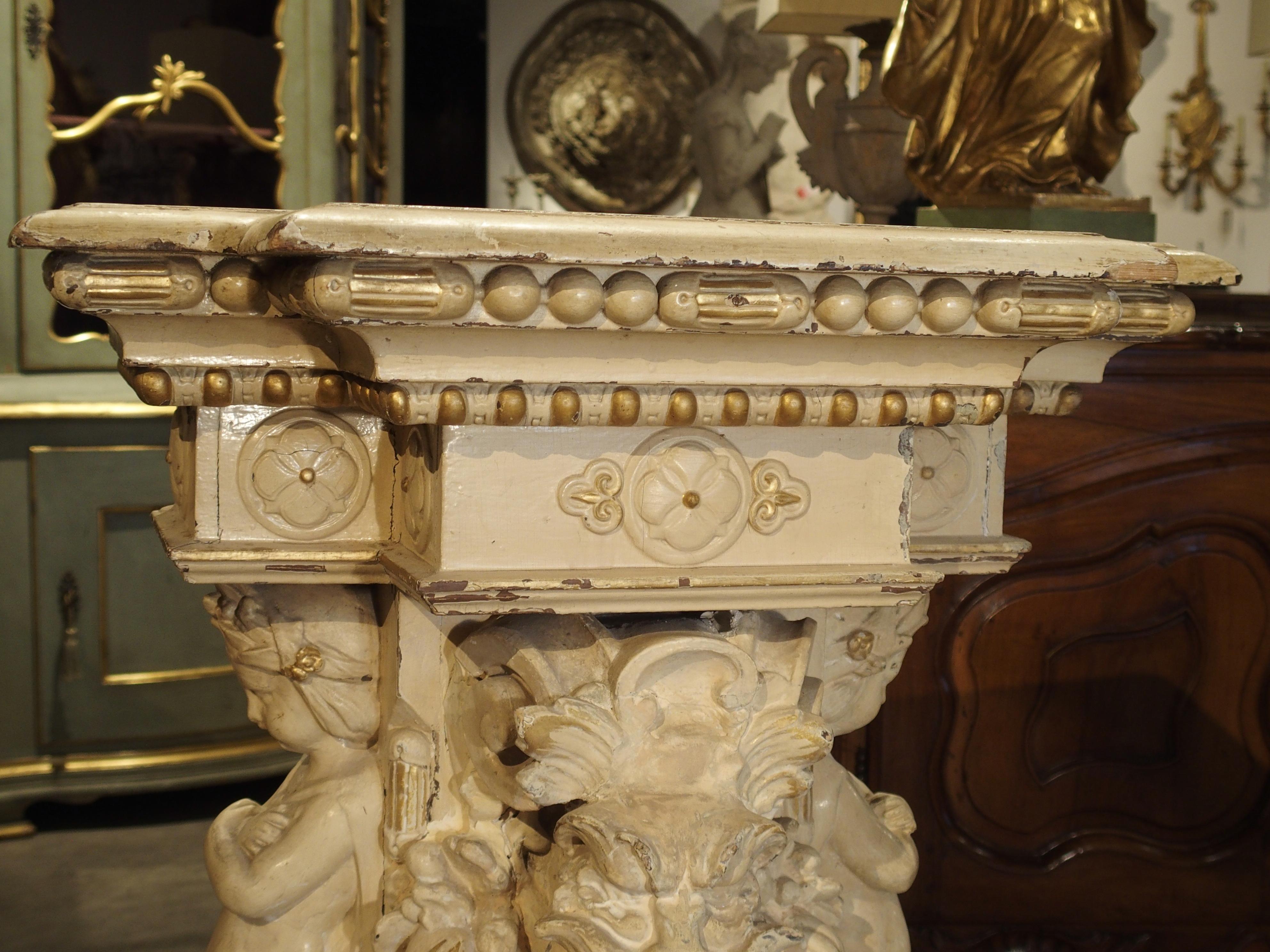 This painted French wall console is from the Napoleon III Period. The top is stepped out, conforming to an apron of linear beaded molding and single quatrefoils centered on each panel of the main apron. Beneath this are three sections featuring a
