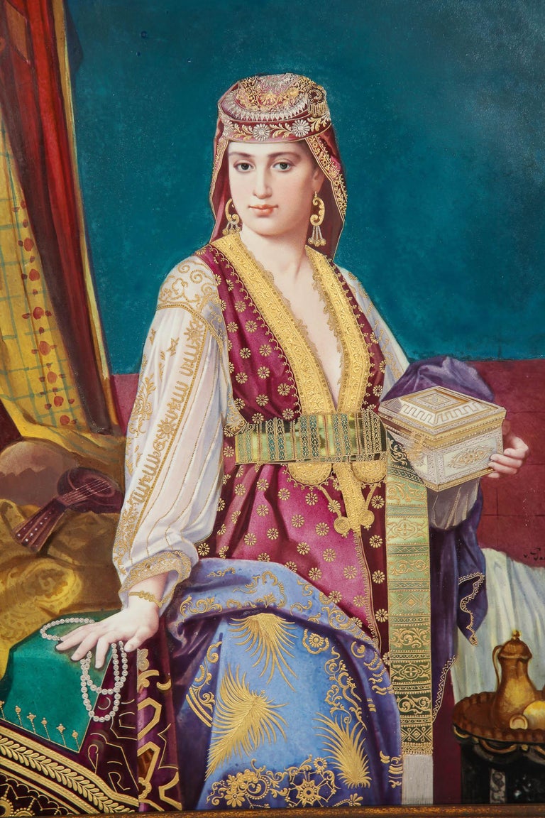 A very large and magnificent antique painted porcelain plaque depicting an orientalist beauty dressed in silk, jewelry, pearls, and 24-karat raised gold and enamel, signed Vienna. This beautiful hand-painted porcelain plaque has been remarkably made