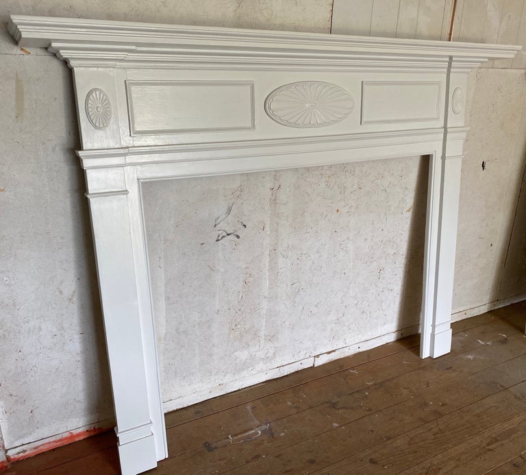 A fine example of Federal style wood fireplace mantel newly refinished and painted having an architectural crown with stepped molding beneath shelf and applied ovals on frieze board. Measures 71