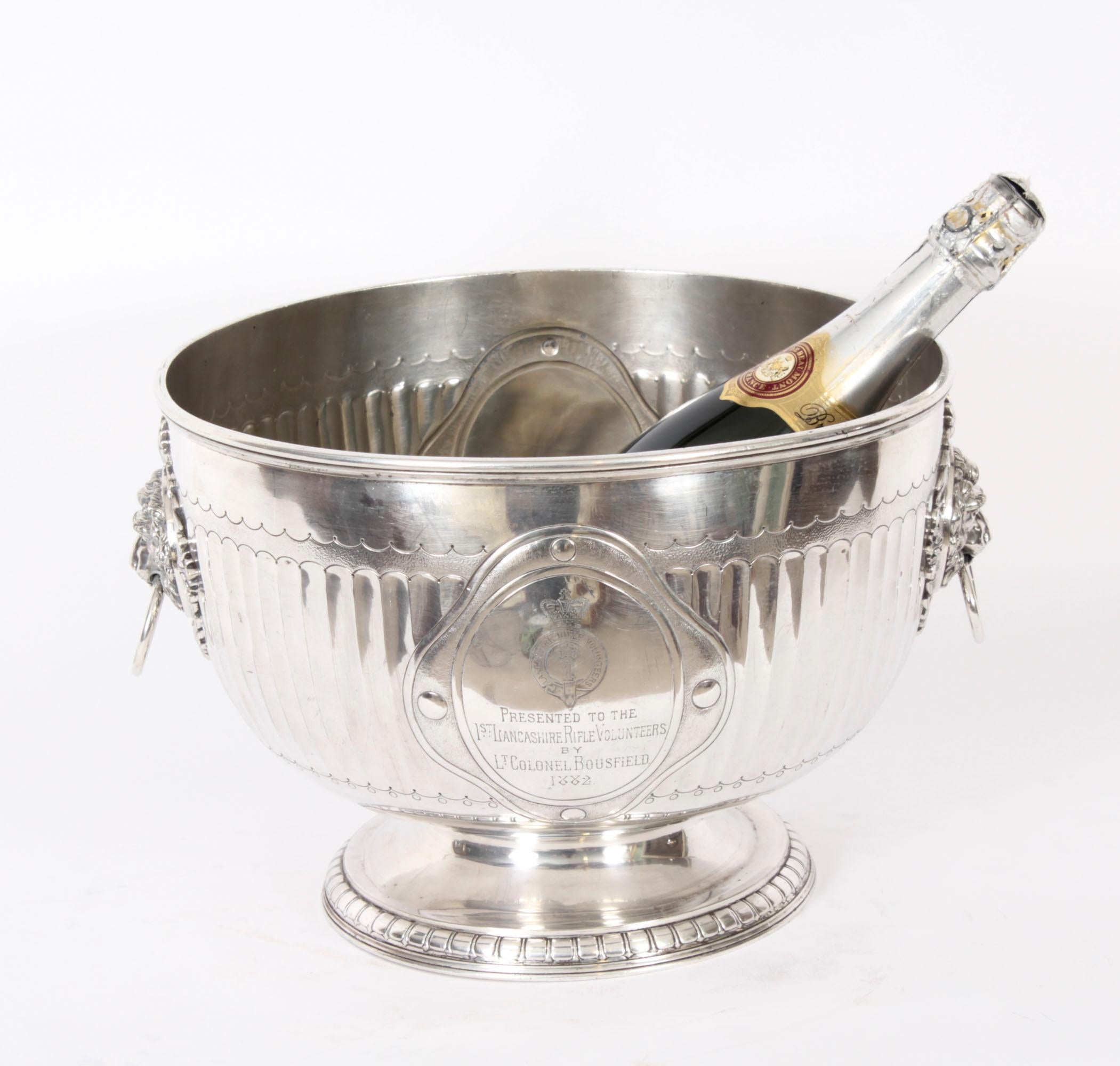 This is an exceptional pair of antique English Neo-classical Revival silver plated wine coolers bearing the makers mark of the renowned English silversmith Elkington, dated 1873.
 
The wine coolers stand on circular pedestal bases on top of reeded
