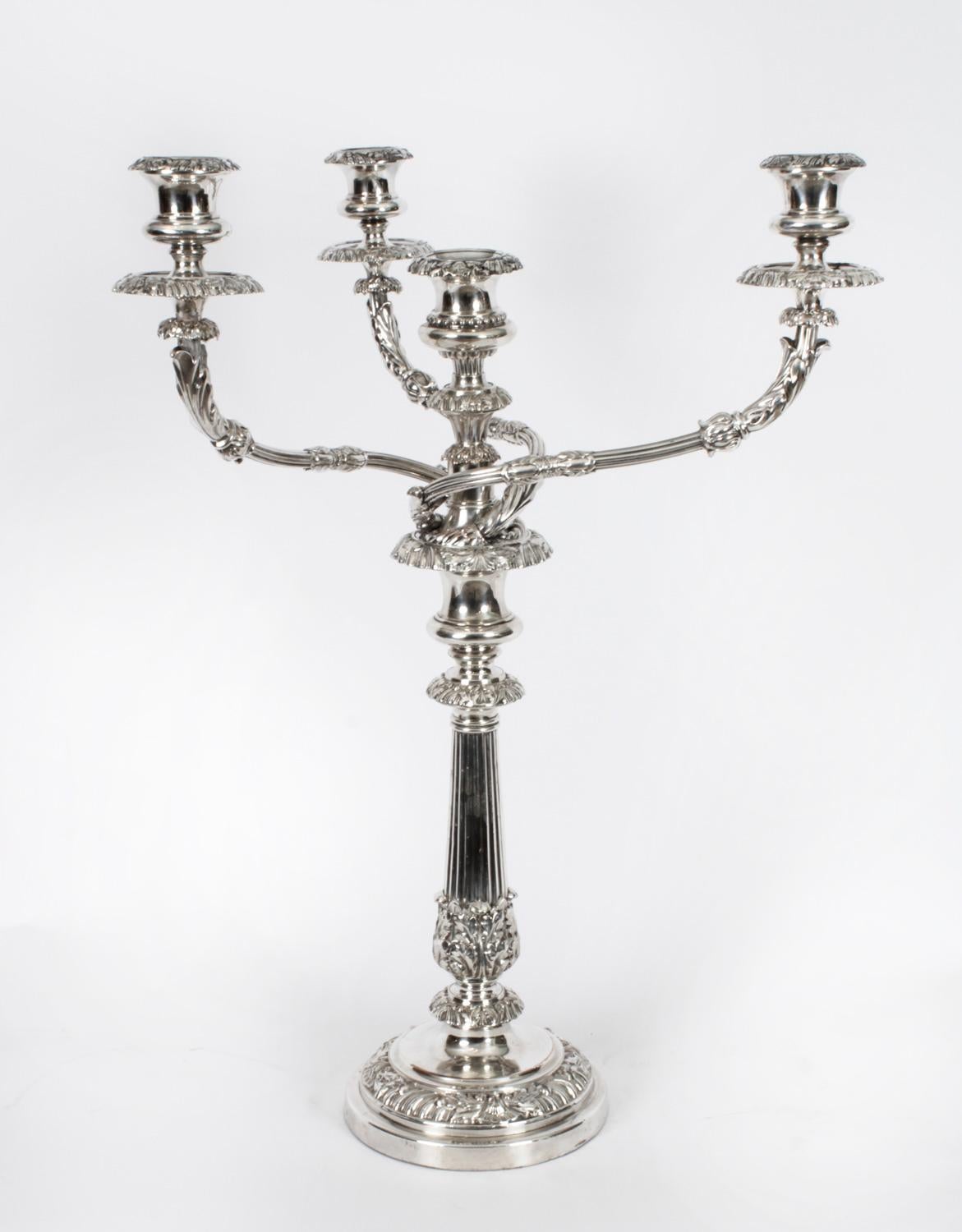This is a stunning monumental pair of antique English Old Sheffield Plate, silver on copper, four light, three-branch table candelabra, circa 1790 in date, and bearing the sunburst makers marks of the world renowned silversmith Matthew Boulton.
