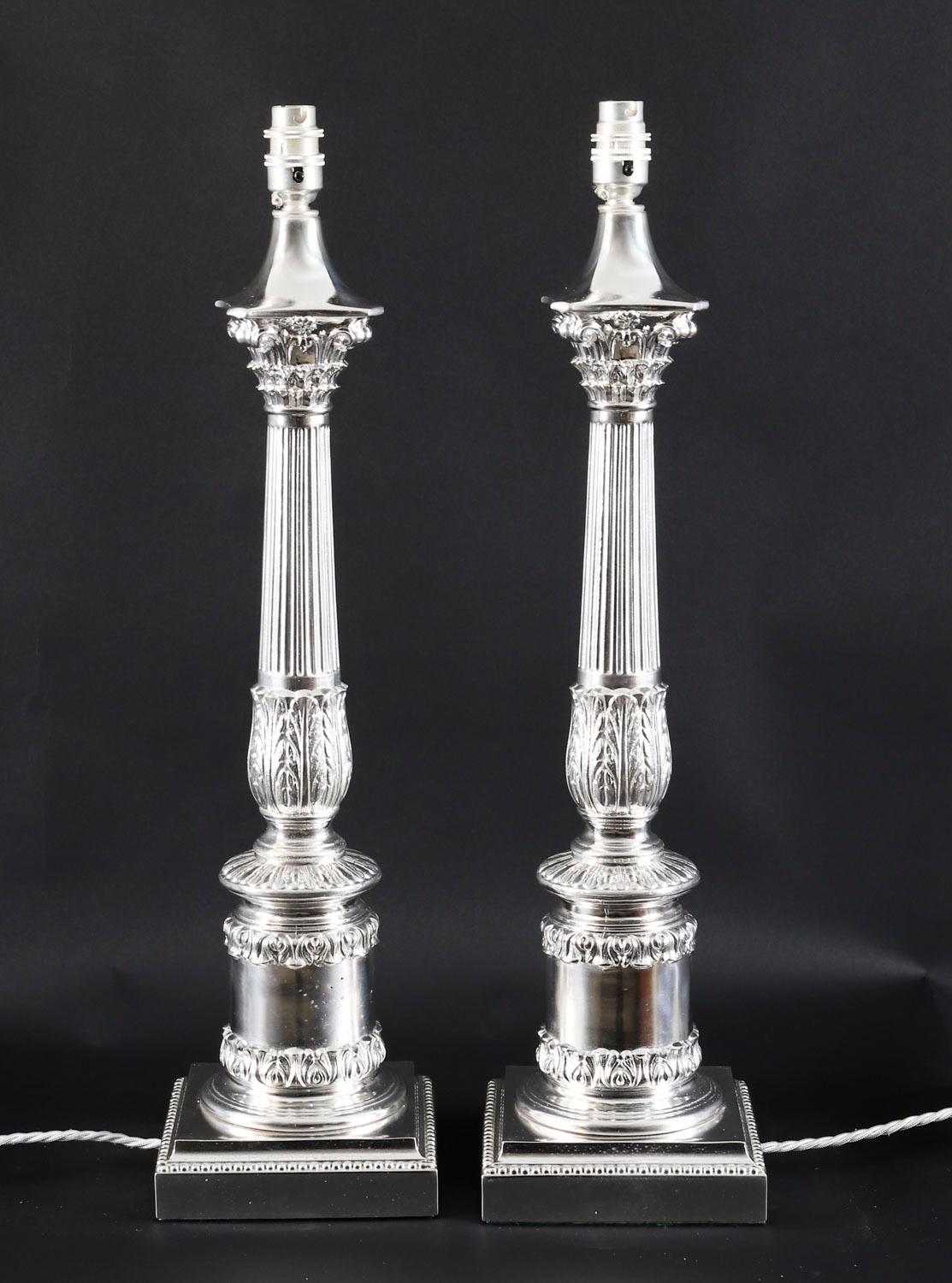 Se trata de una impresionante pareja de lámparas de mesa eduardianas de columna corintia bañadas en plata, fechadas hacia 1910.
 
Cada lámpara presenta un capitel corintio clásico decorado con hojas de acanto y antemuro con fuste estriado sobre un