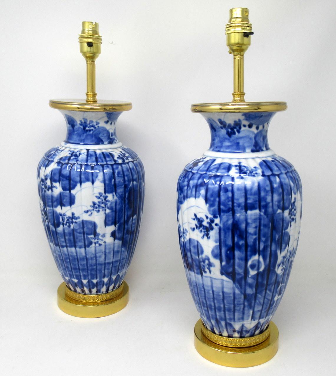 Stunning pair of traditional bulbous form Art Deco period blue and white ribbed porcelain vases of generous proportions, now converted to a pair of electric table lamps, possibly of Chinese or European origin, complete with later circular ormolu