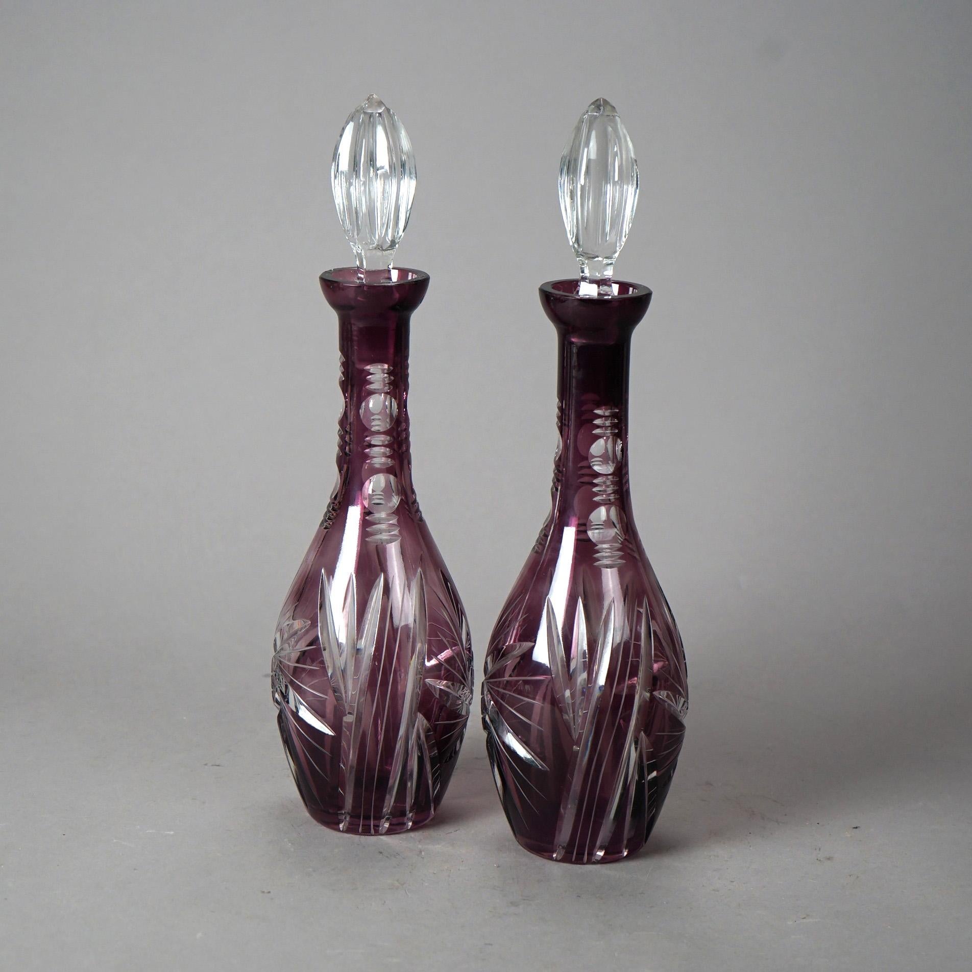 An antique pair of Bohemian decanters offer amethyst cut to clear glass construction with sunburst design and stoppers, circa 1920

Measures - 14.25