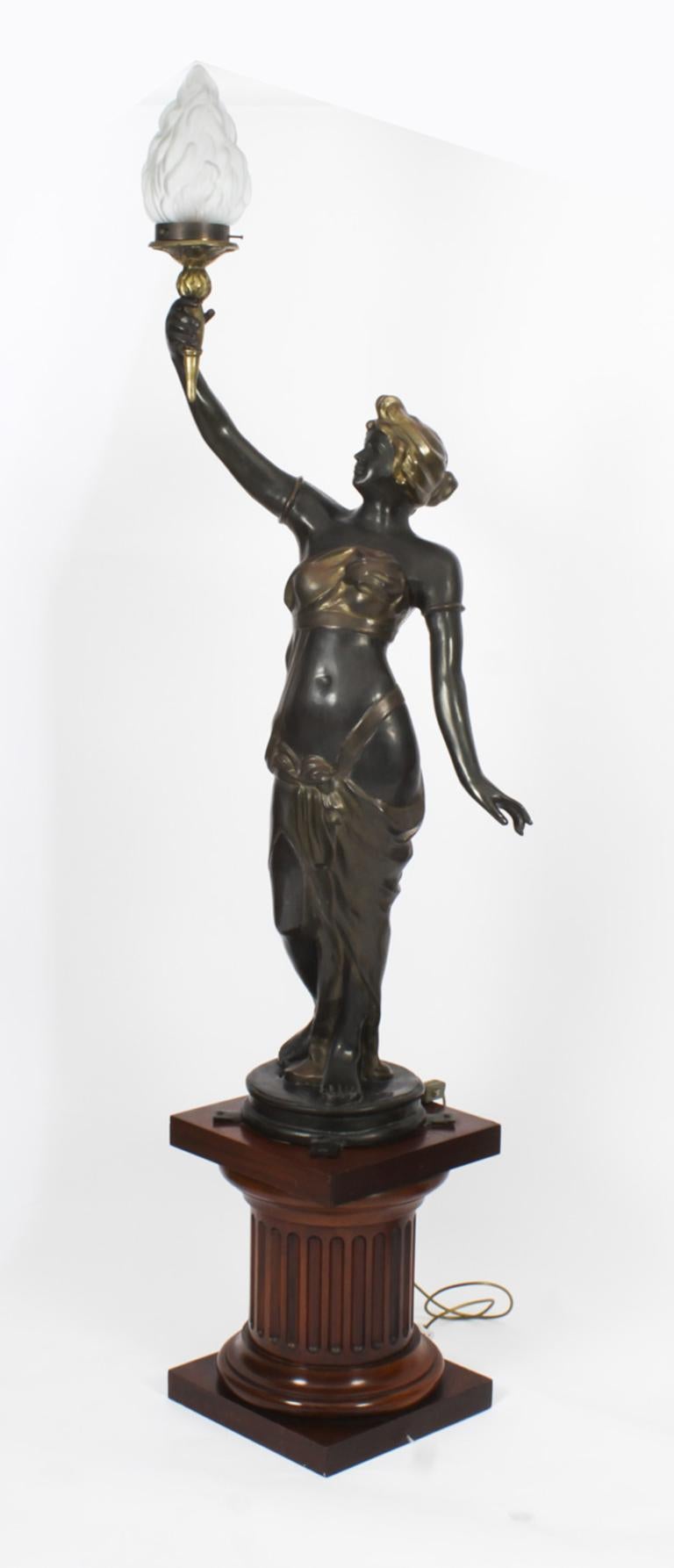 A truly stunning pair of bronze figural torcheres set on fluted Doric column bases later converted to electricity, circa 1910 in date
 
The ladies are adorned in long and flowing classical gowns typical of ancient Greece or Rome, each holding