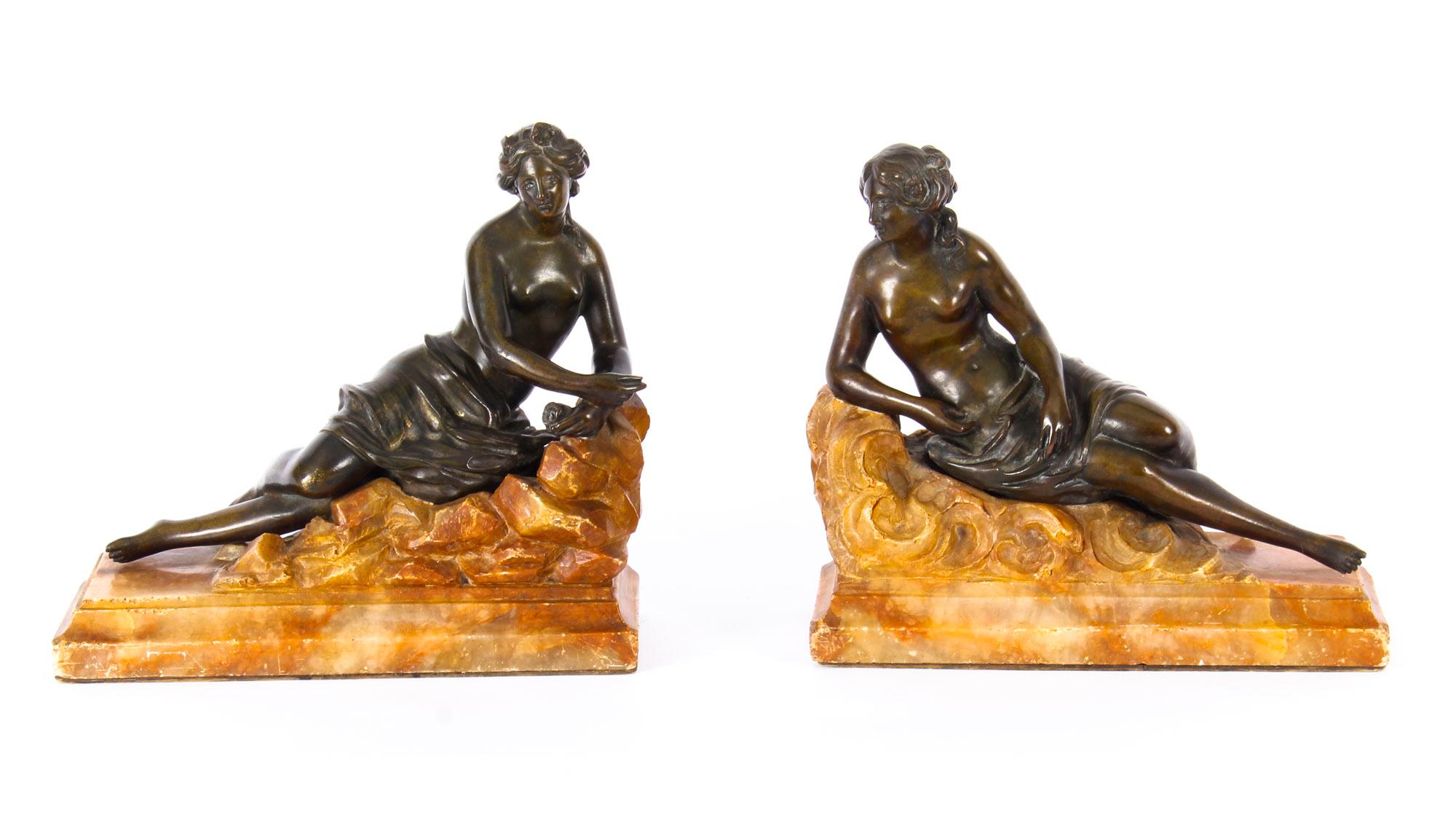 This is a stunning antique pair of patinated bronze reclining Classical semi-nude sculptures of young ladies mounted on carved marble bases, circa 1880 in date.

These exceptionally sculptured bronze figures feature two beautiful youthful women