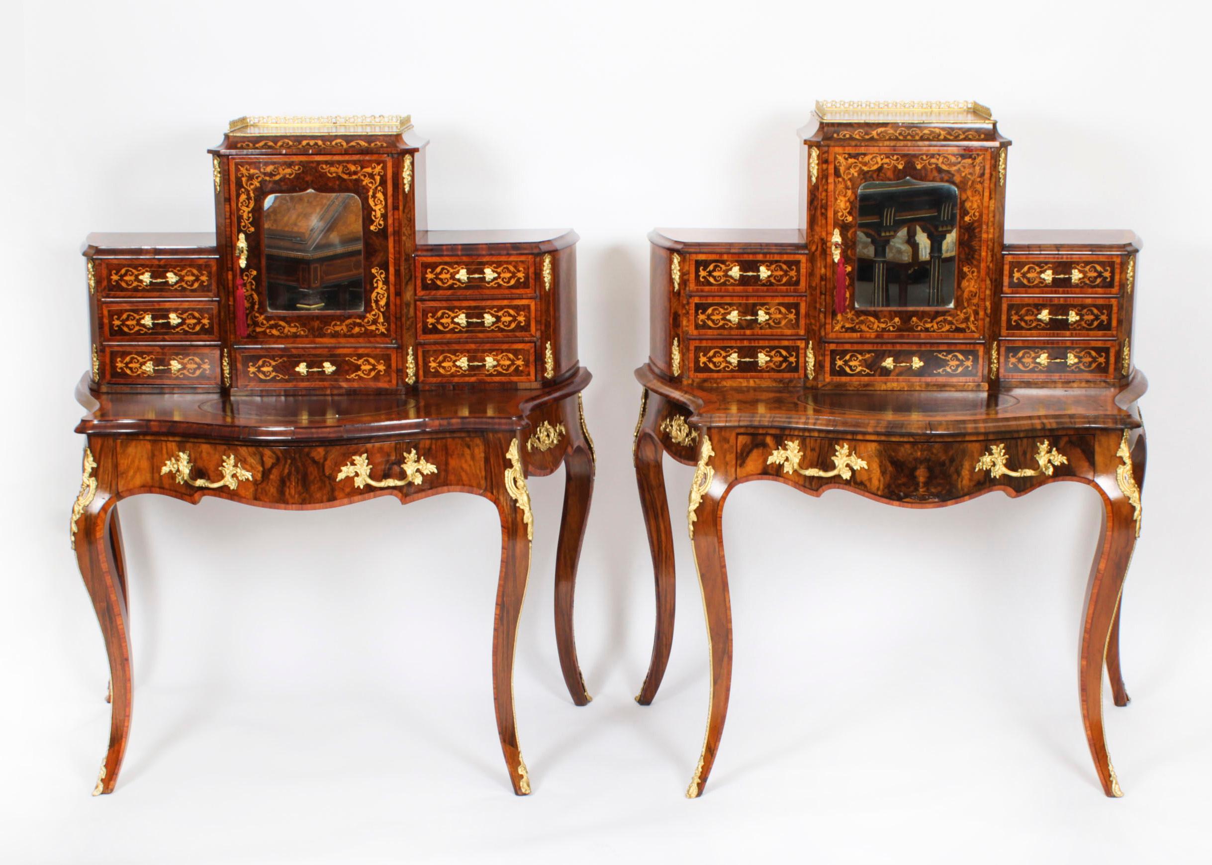 This is an elegant pair of Victorian burr walnut and marquetry Bonheur Du Jour's, or Ladies writing desks, circa 1860 in date. 
 
They feature superstructures that each comprises a large central bay with a mirror inset door and a three quarter