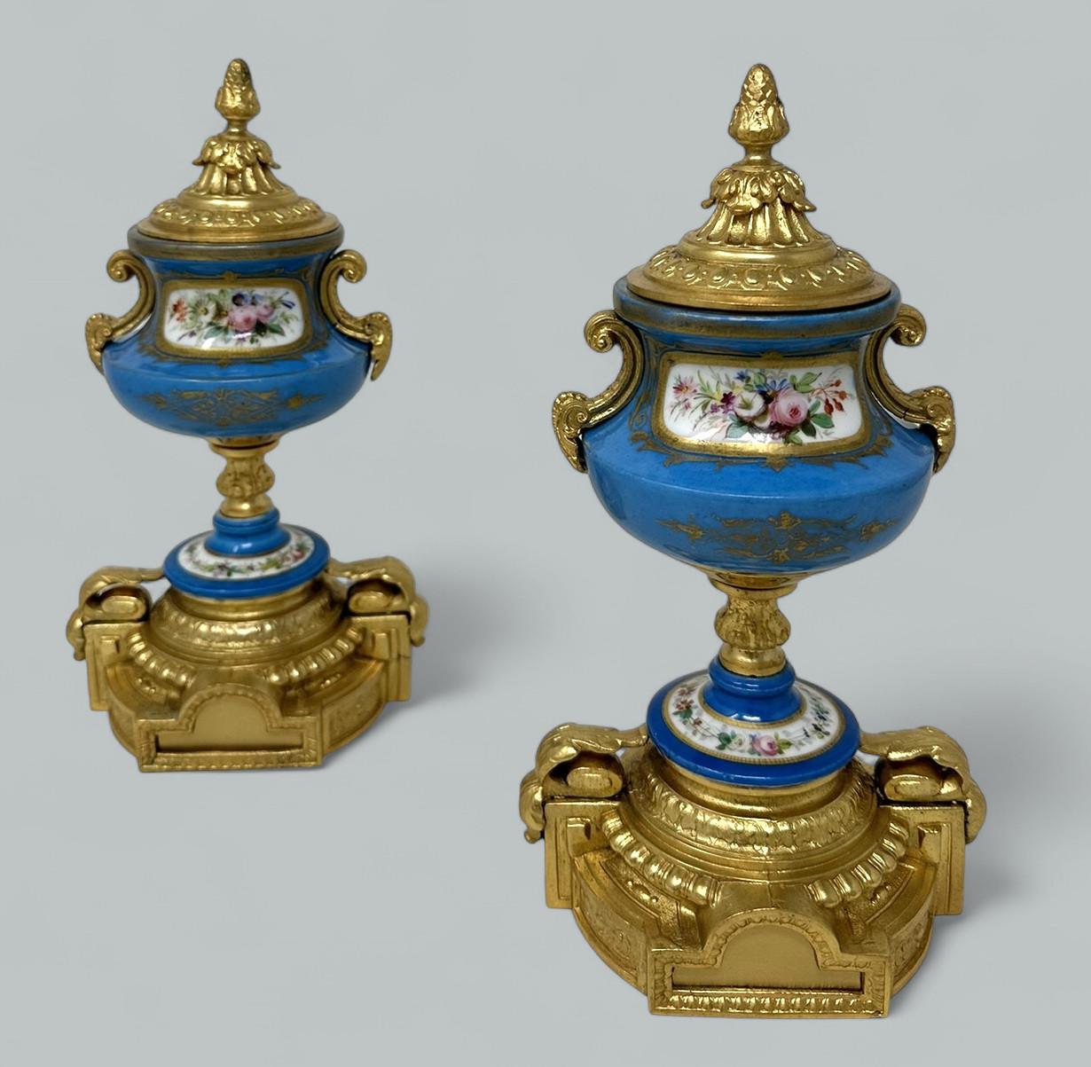 Stunning Pair of French Sevres Soft Paste Enameled Porcelain and Ormolu Twin Handle Table or Mantle Urns of traditional urn form and of outstanding quality, and medium size proportions, each raised on an oval stepped base flanked by acanthus