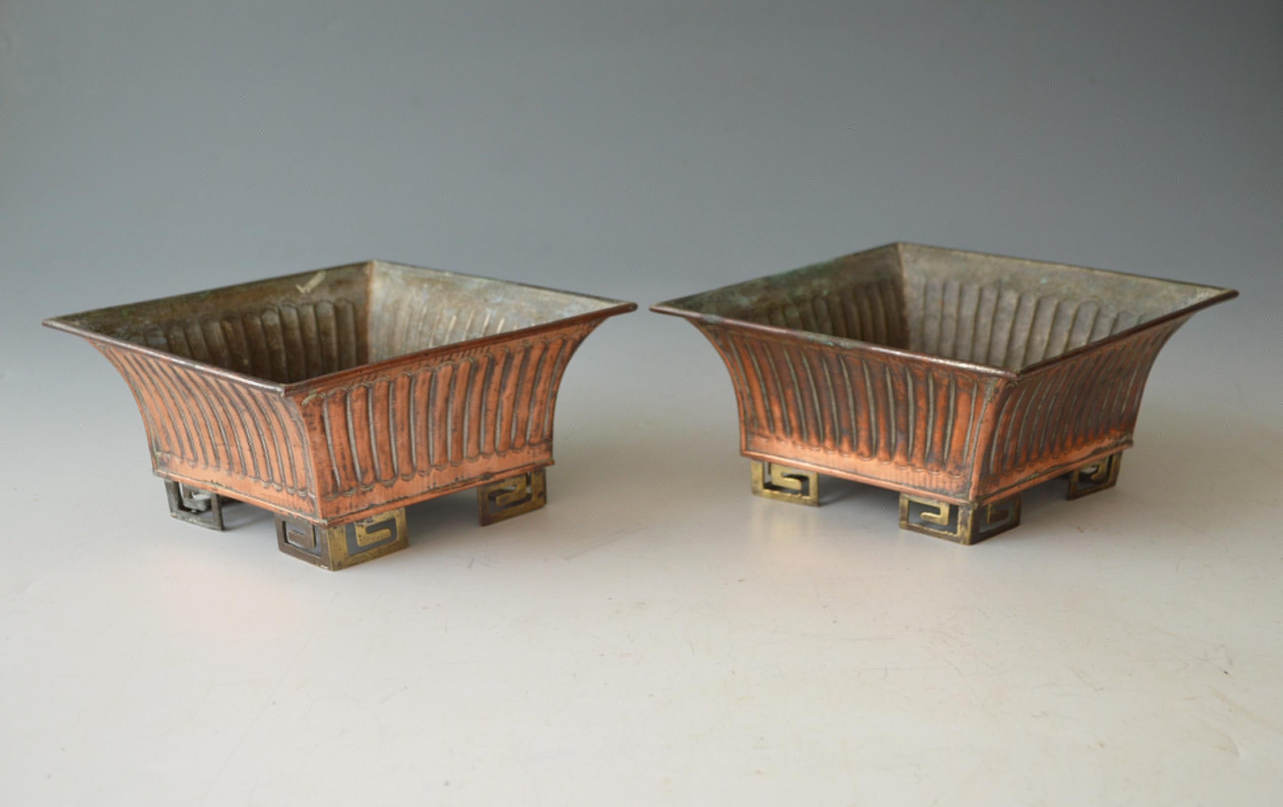 A fine elegant pair of Chinese copper planter sand planters in the arts and crafts style 
Diamond shaped ribbed upper with brass geometric base
Period early mid 20 th century.
Size 25 x 19 x 9 cm.
Nice things
 