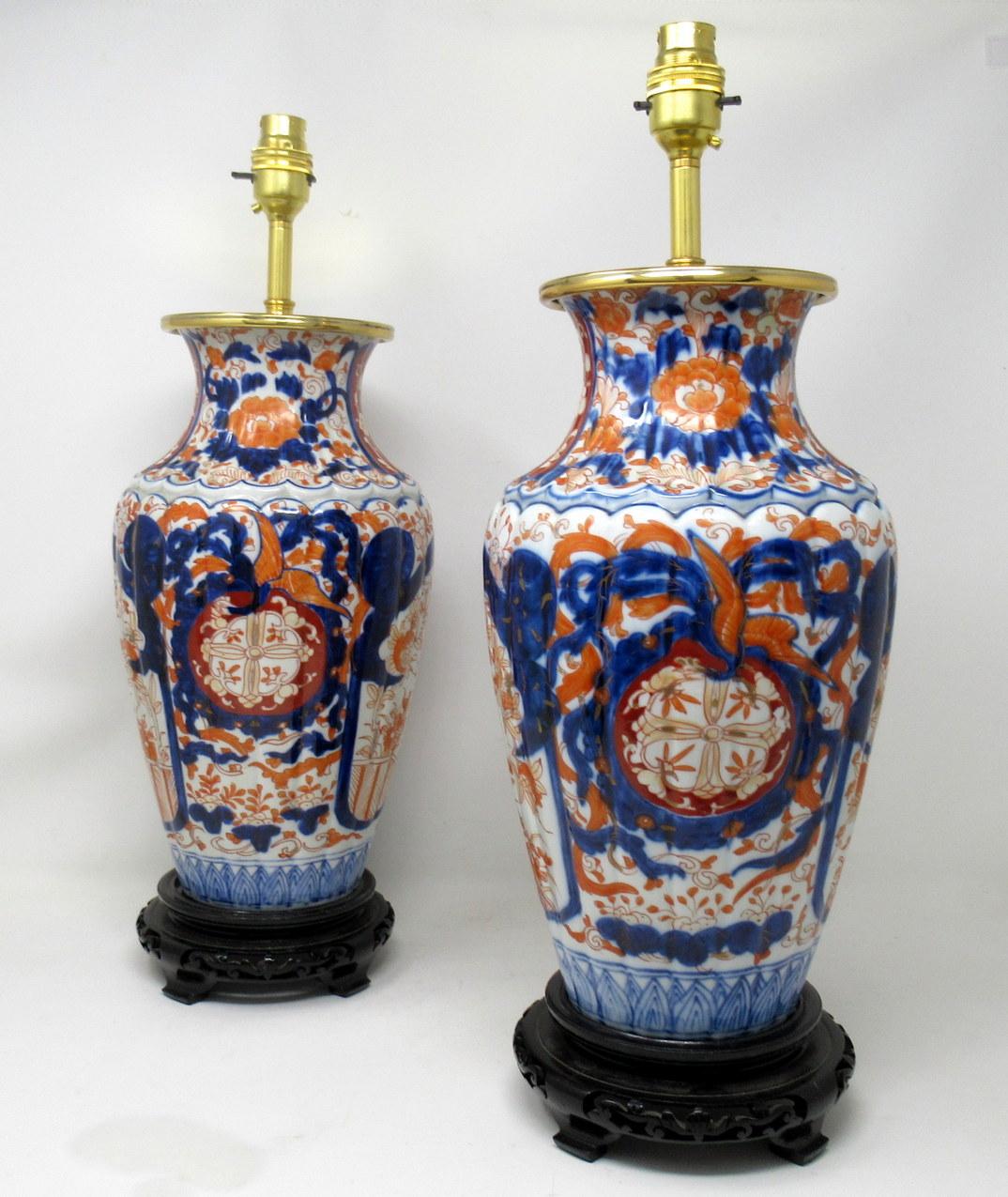 Stunning pair of traditional Japanese Imari Bulbous form Porcelain vases of generous proportions, now converted to a pair of electric table lamps, complete with their original fret work decorative hardwood ebonized circular bases with four block