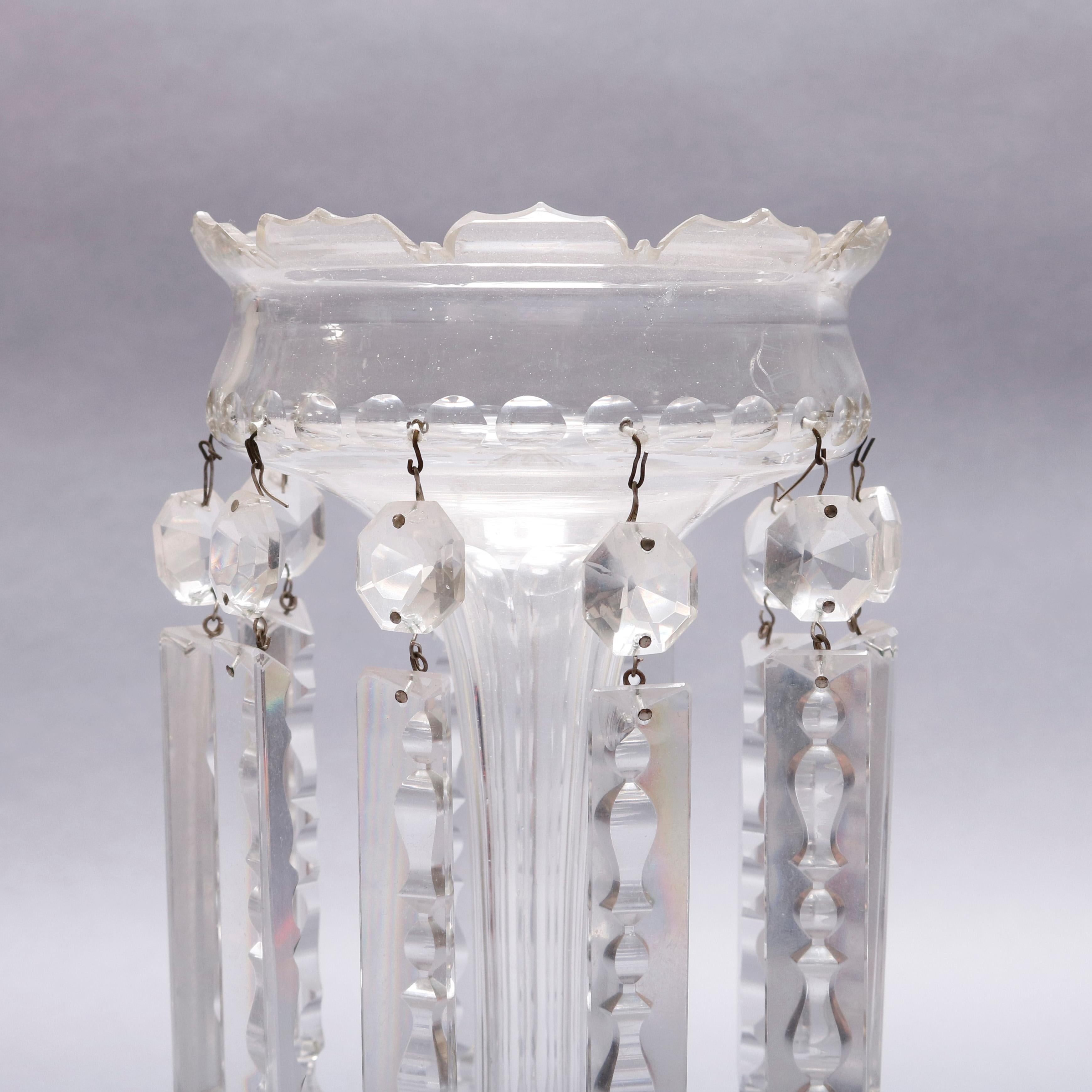 An antique Bohemian School crystal pair of mantel lusters feature colorless crystal construction with crown form bowls decorated with hanging cut crystals and surmounting faceted columns on thumb print bases, circa 1880.

Measures: 13