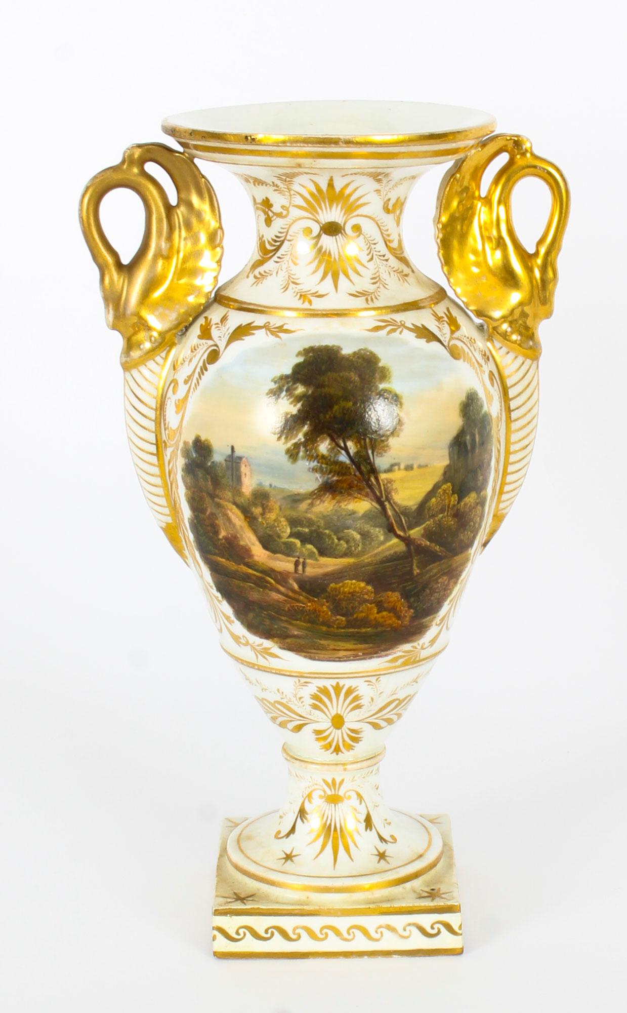 This is a truly superb pair of Derby twin handled square based slender ovoid cabinet vases, circa 1790 in date and bearing the Derby painted mark with crown and D on the undersides.

With gilt leaf moulded swan neck handles and delicate scrolled