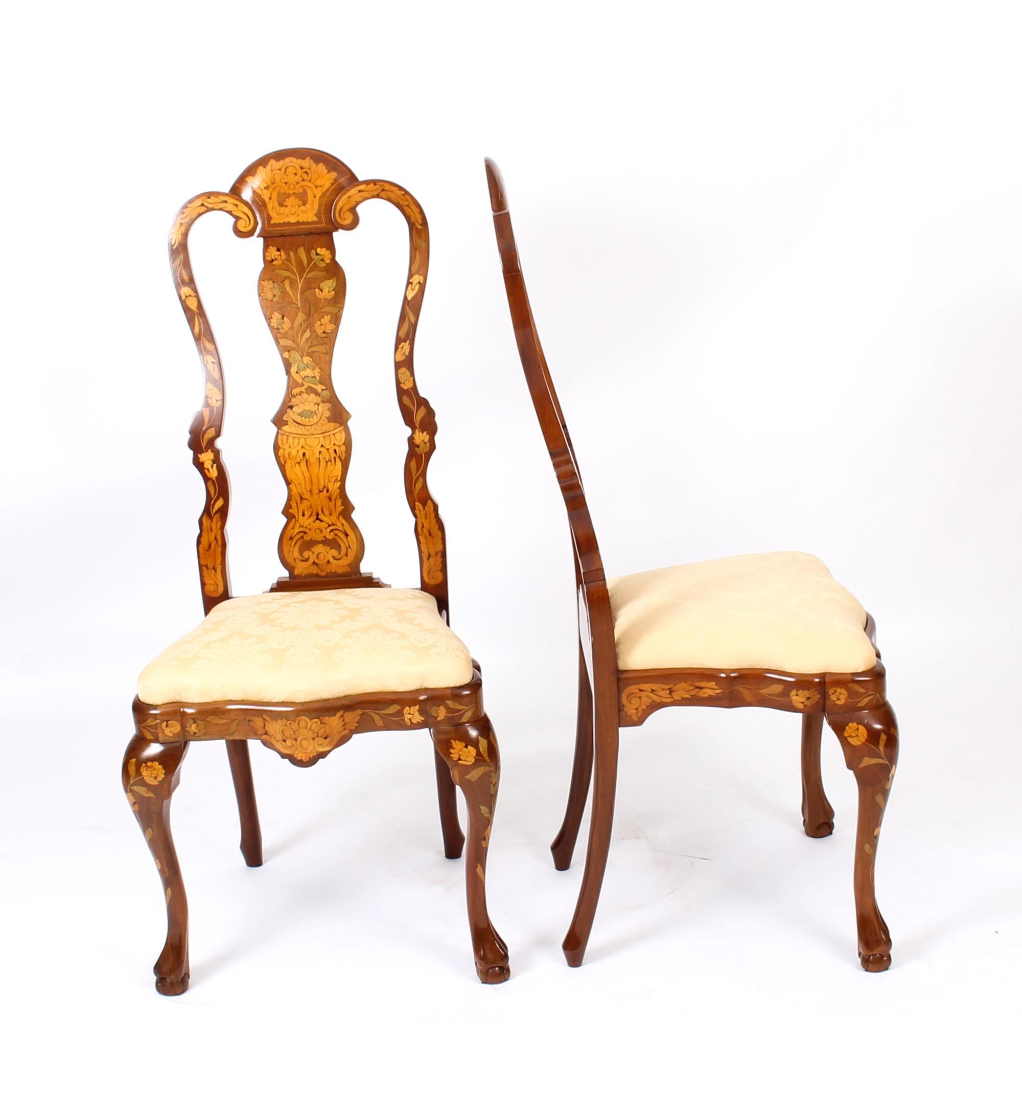 This is a stunning and rare pair of antique high backed Dutch walnut and floral marquetry dining chairs, typical of the very best late 19th century Dutch furniture. 

The chairs have been skillfully crafted from walnut, and bear profuse floral and