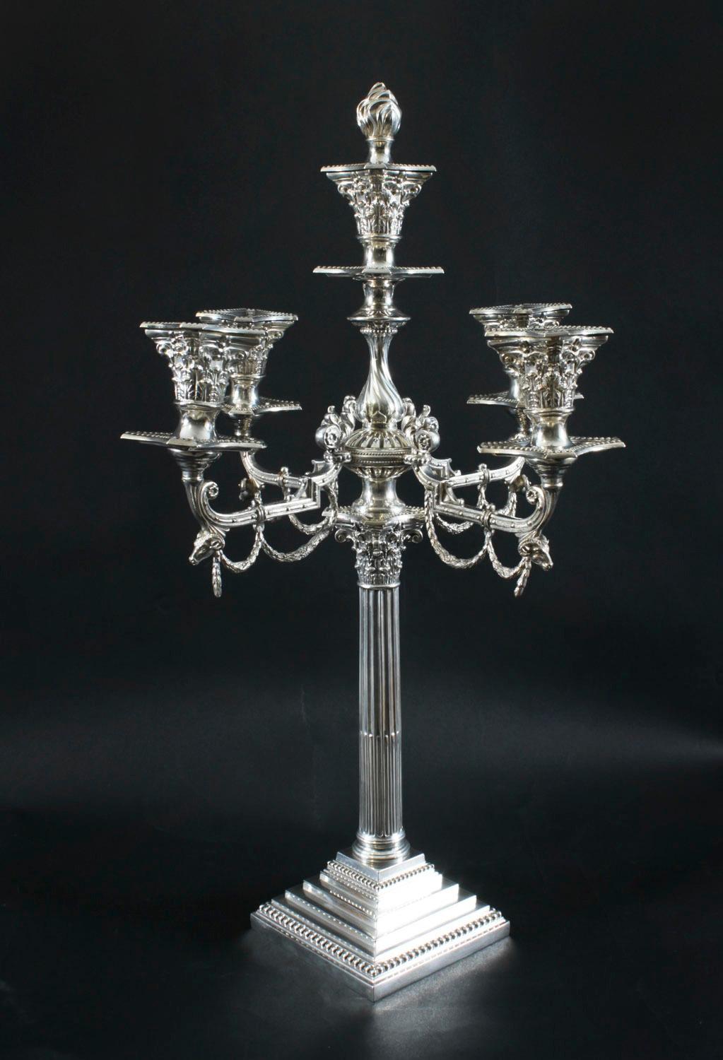 Si tratta di una splendida coppia di antichi candelabri inglesi di design neo-classico George III revival, placcati in argento, a cinque luci e a quattro bracci con colonna corinzia, datati circa 1900.

I candelabri sono caratterizzati da rami a