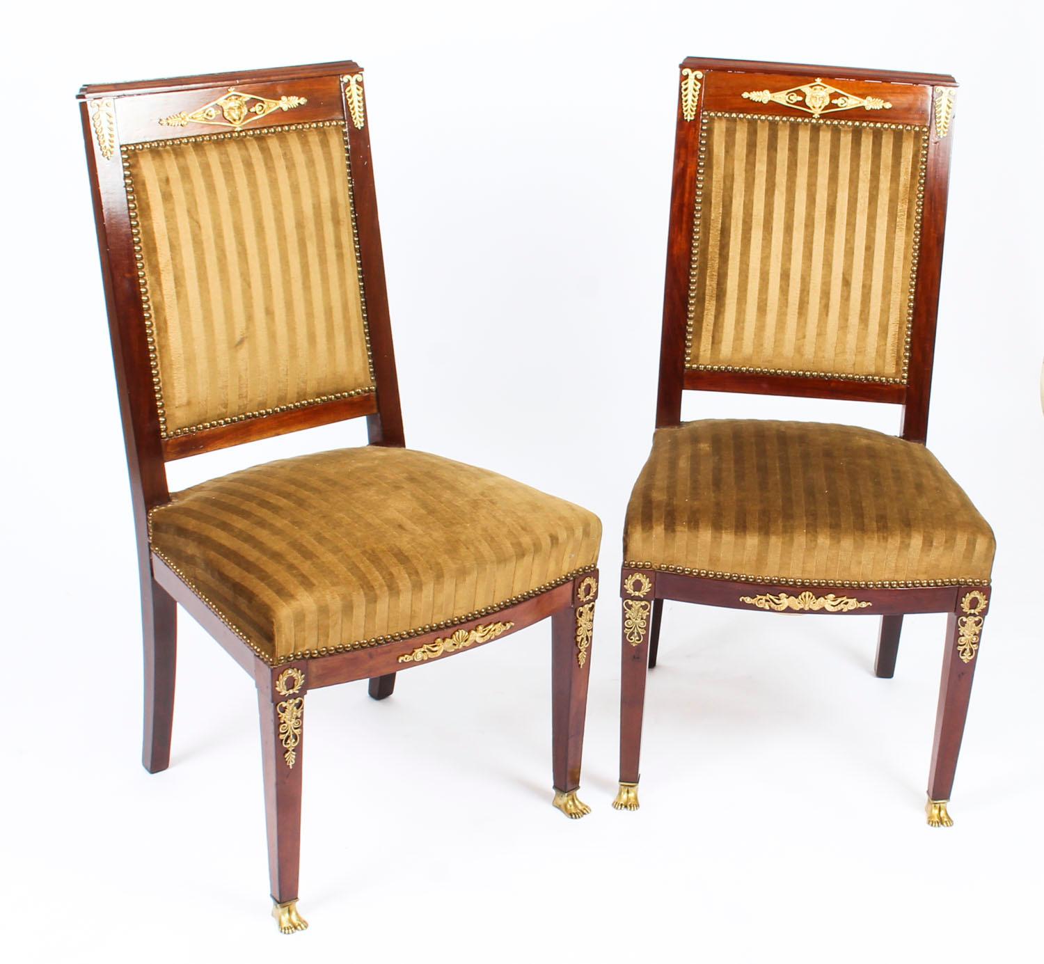 This is a fantastic and highly decorative antique French gilt bronze mounted Empire Revival pair of side chairs, circa 1880 in date.

Crafted from fabulous solid mahogany and smothered in fabulous high quality ormolu mounts reminiscent of the